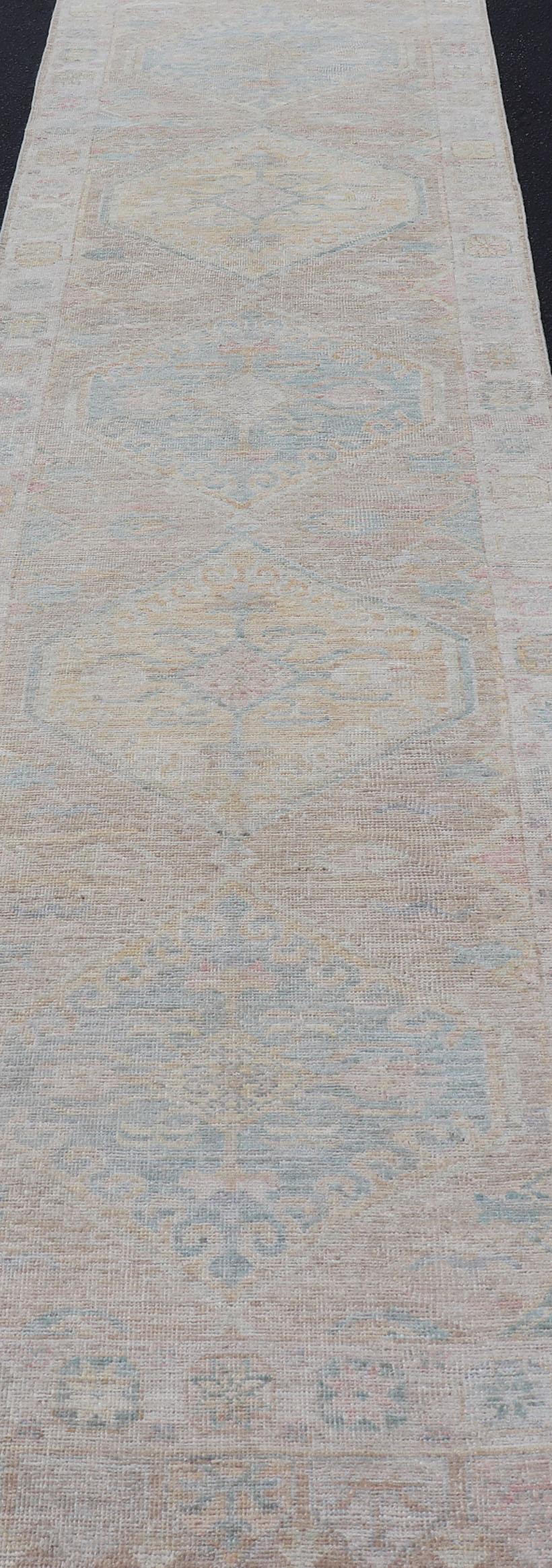 Moderner Oushak mit heller Koralle und blauen Motiven auf hellem taupefarbenem Hintergrund (Handgeknüpft) im Angebot