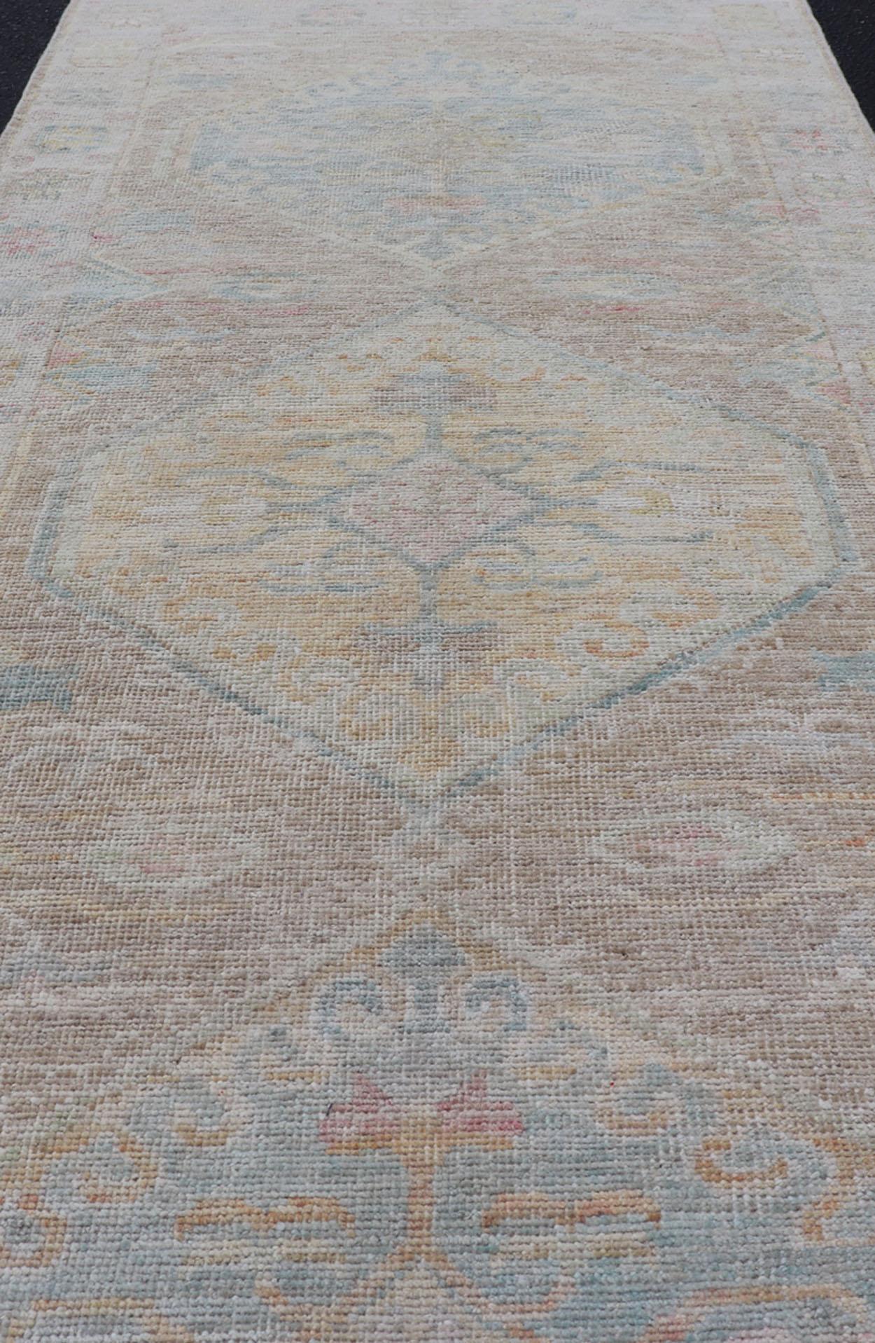Moderner Oushak mit heller Koralle und blauen Motiven auf hellem taupefarbenem Hintergrund (21. Jahrhundert und zeitgenössisch) im Angebot