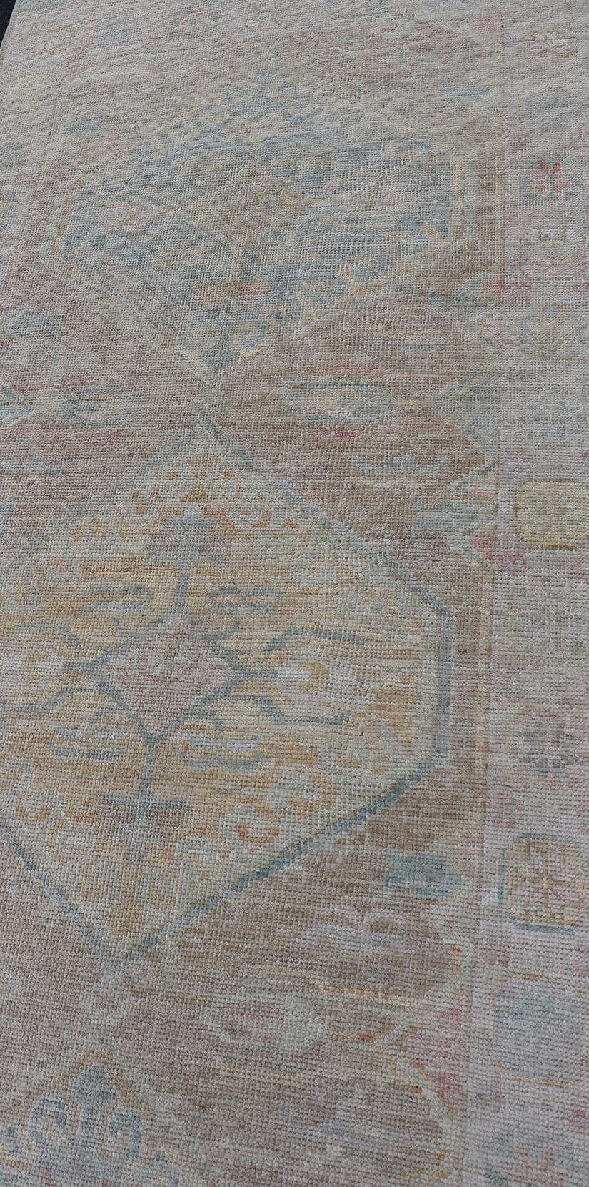 Moderner Oushak mit heller Koralle und blauen Motiven auf hellem taupefarbenem Hintergrund (Wolle) im Angebot