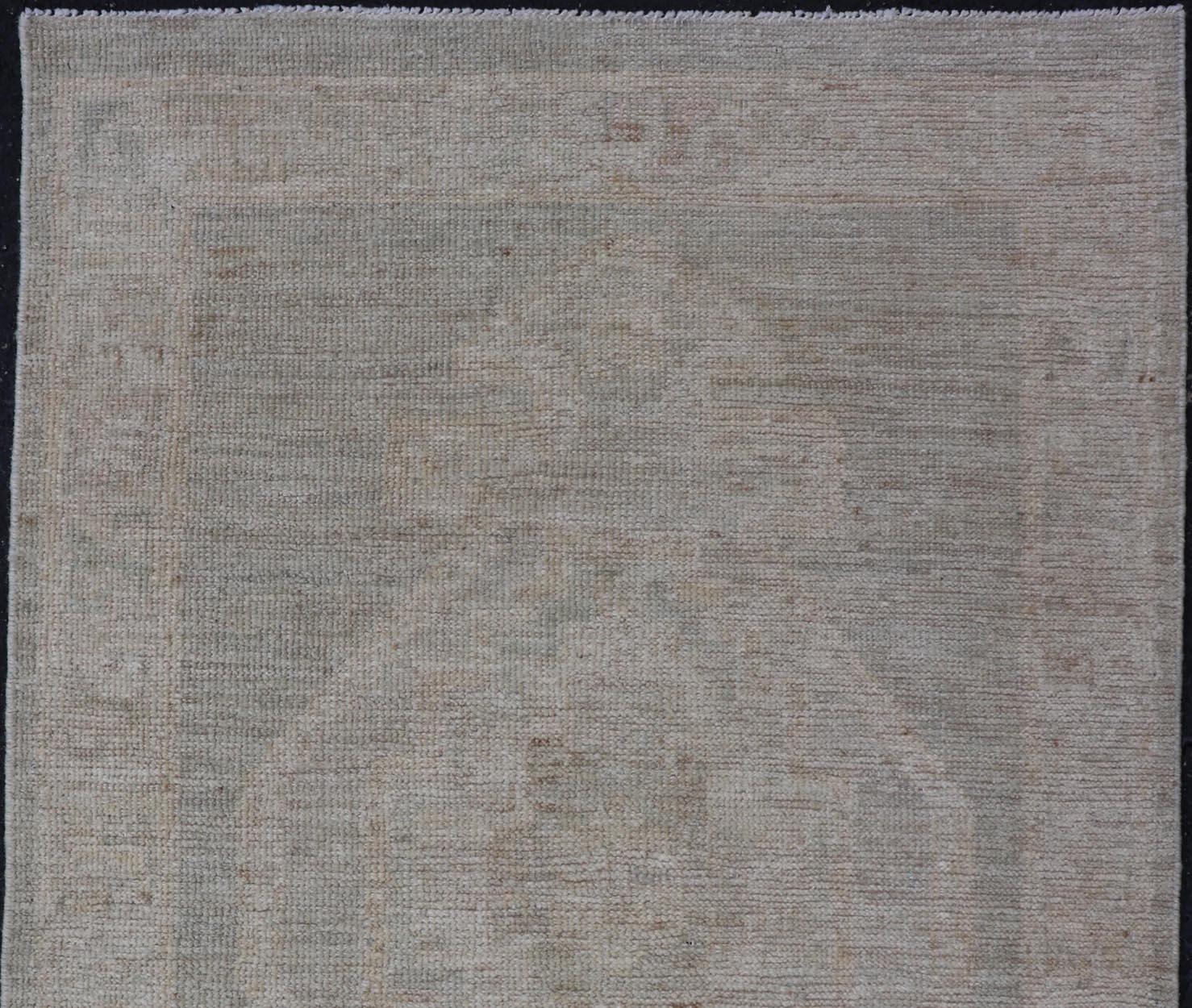Annodato a mano Oushak moderno con sfondo grigio sporco e un grande medaglione tribale in crema in vendita