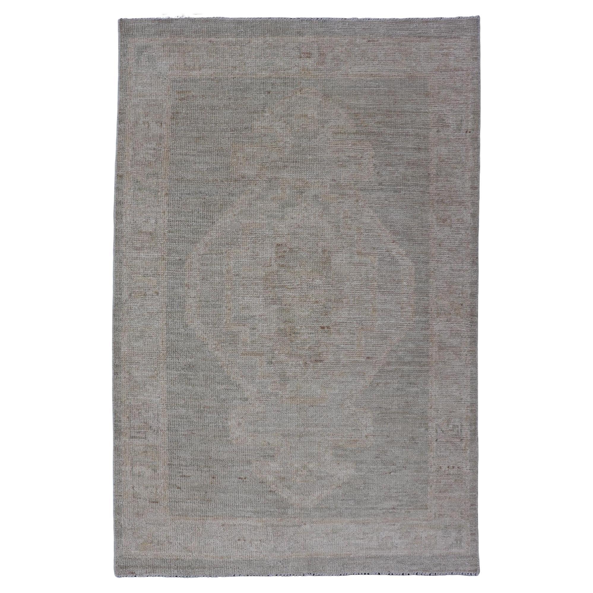 Moderner Oushak mit cremefarbenem Hintergrund und großem Stammesmedaillon in Creme