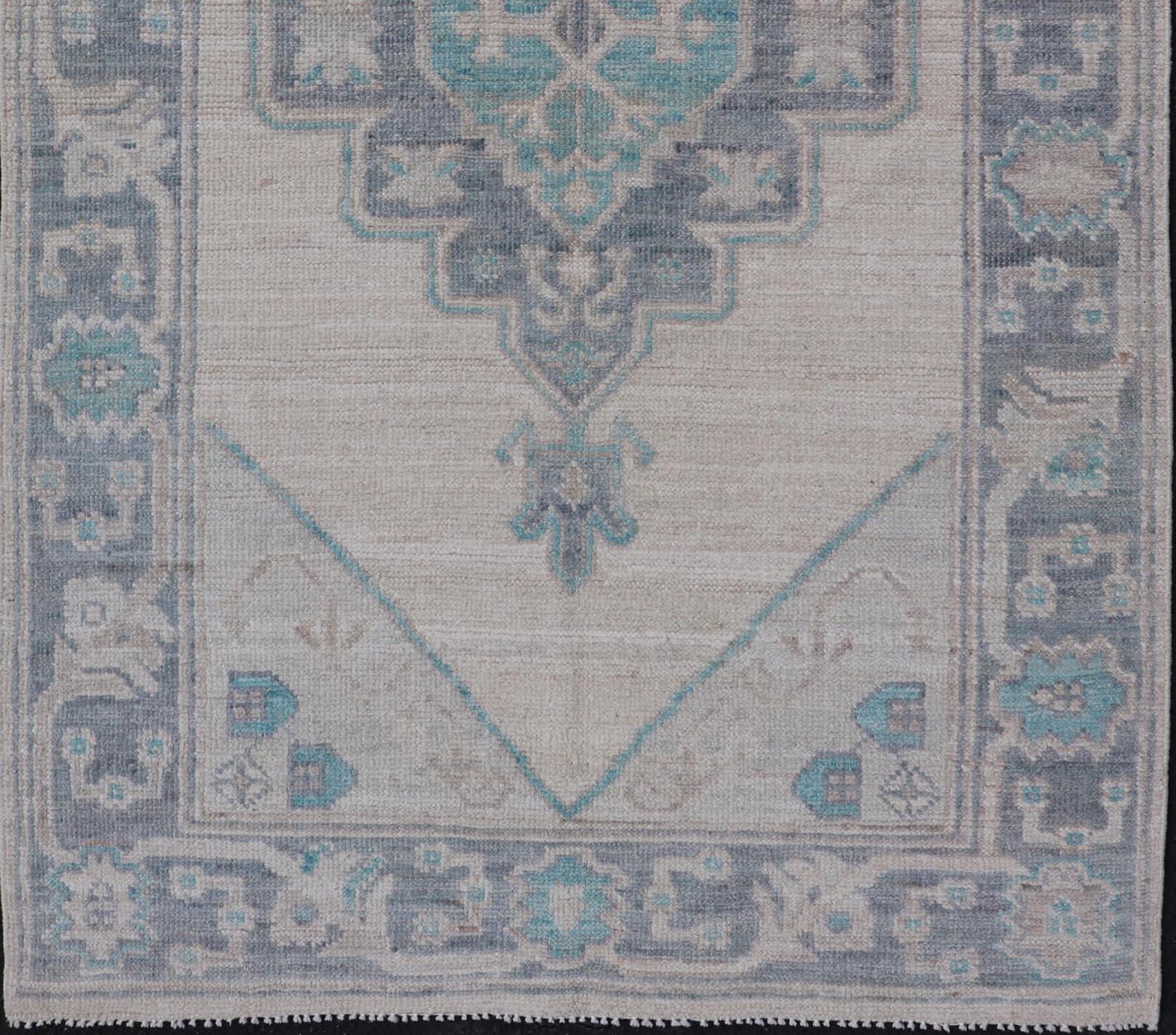  Modern Oushak with Off White Background with A Large Tribal Medallion in Teal.

Measures: 3'1 x 5'3 

This Oushak featuring a center tribal medallion in the center of off white background and the light gray border also. Colors are gray, cream, Off