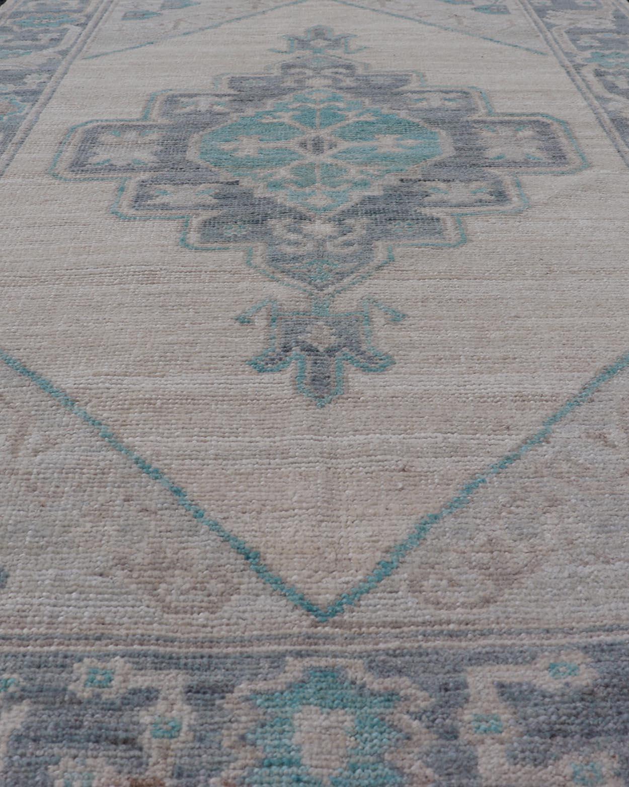 Hand-Knotted Modern Oushak with Off White Background with A Large Tribal Medallion in Teal  For Sale
