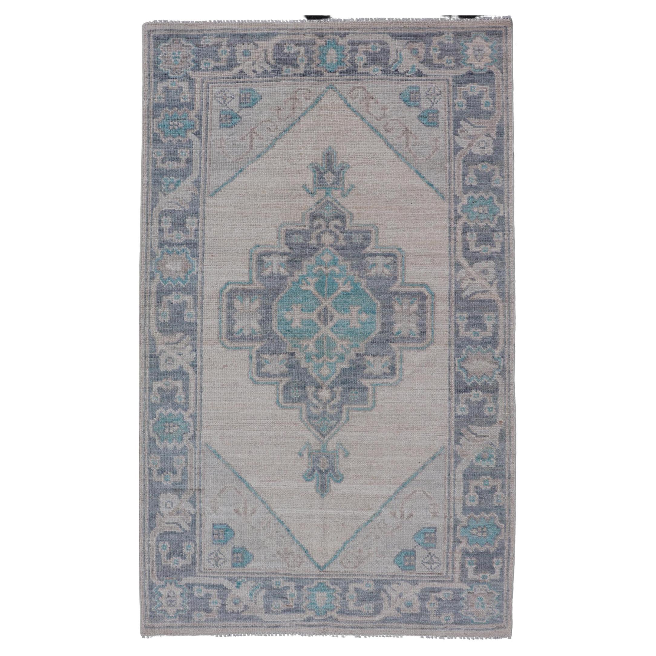 Modern Oushak with Off White Background with A Large Tribal Medallion in Teal  For Sale