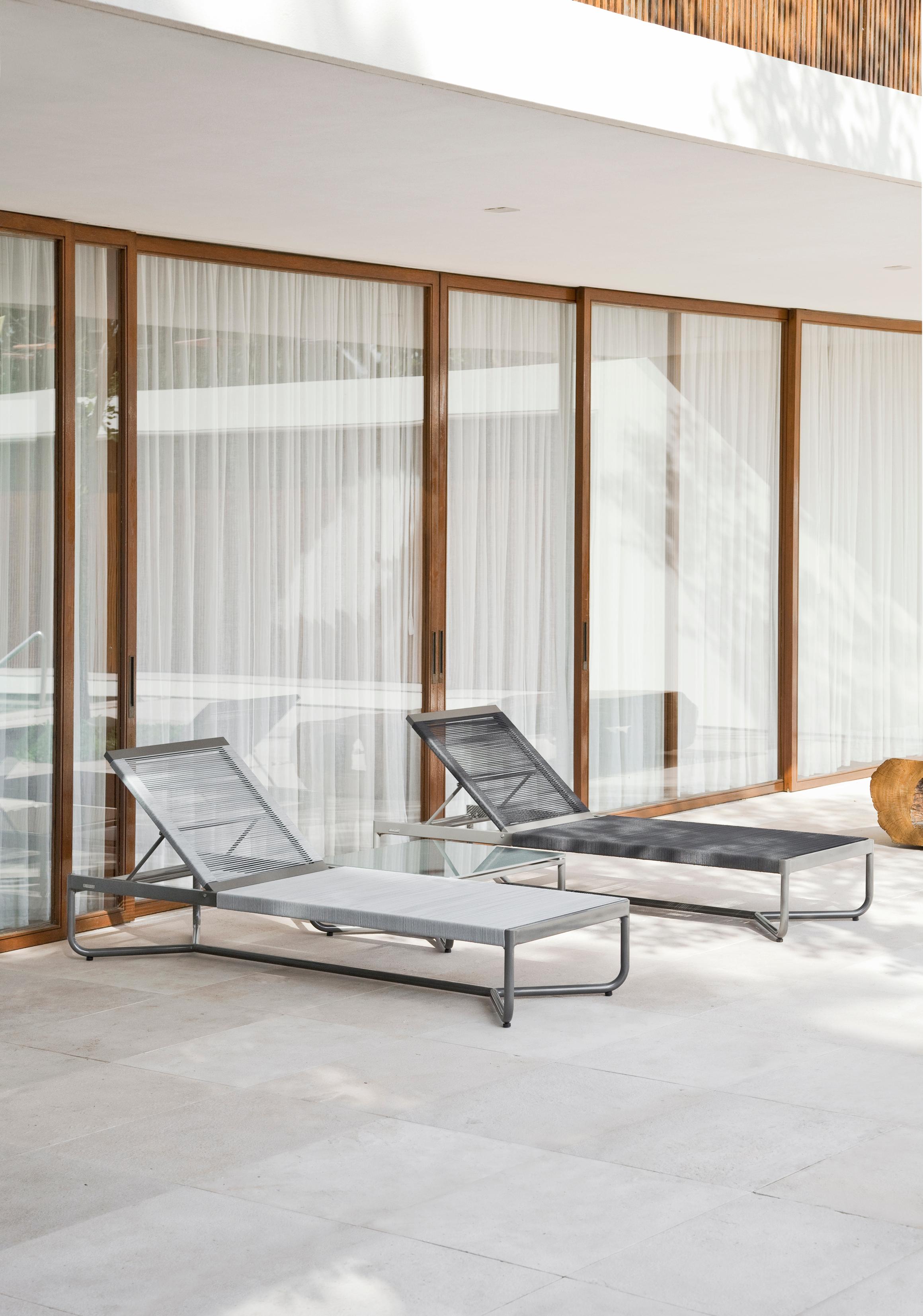 Cette chaise longue ou bain de soleil moderne est conçue pour un usage extérieur. Il fait partie de la collection Flap 2.0 Outdoor, dont le design s'inspire des volets d'avion. Cet élément est visible dans la courbure des bras et la géométrie de la