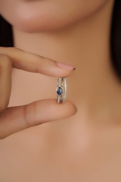 Anillo moderno de doble banda con zafiro azul ovalado y diamantes en oro blanco de 14 quilates