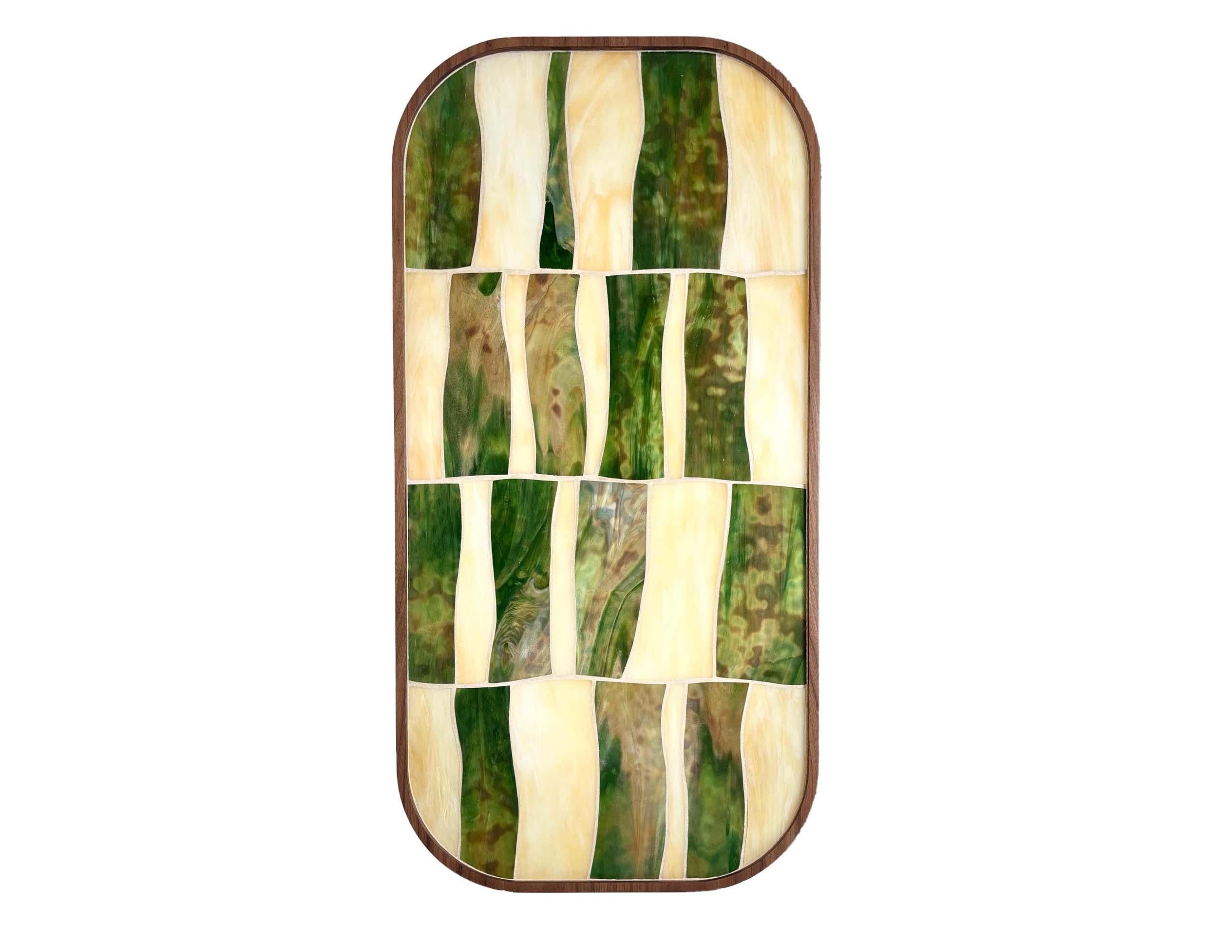 Palazzo oval coffee table with og green and ivory glass sits on Walnut Wood pedestals by Ercole Home. 

A sleek table with high craftsmanship and flowing mosaic patterns. The ivory and green glass is embedded into carved out refined walnut wood.