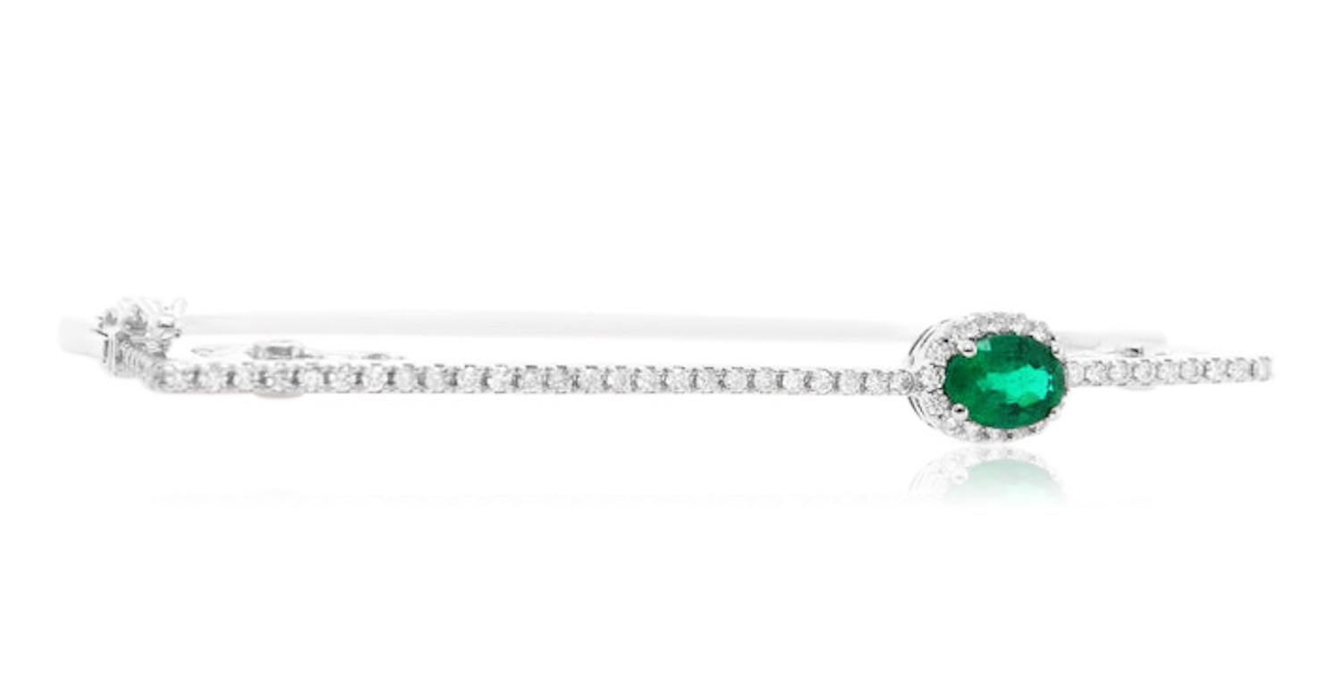 Material: 14K White Gold 
Stone Details: 1 Oval Emerald at 0.8 Carats Total- Measuring 7 x 5 mm
Diamond Details: 66 Brilliant Round Diamonds at 0.65 Carats- Clarity/ S-I: Color/ H-I

Fine one-of-a-kind craftsmanship meets incredible quality in this