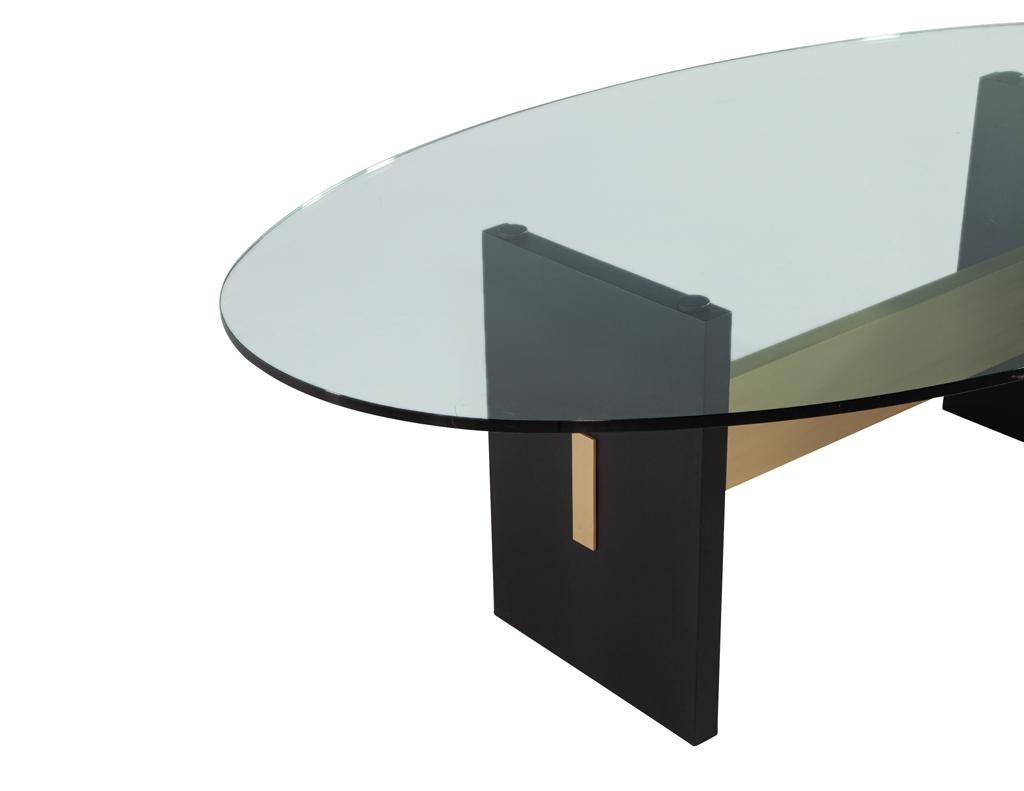 Moderner ovaler Esstisch mit Glasplatte und handgefertigtem Metallsockel (Beschichtet) im Angebot