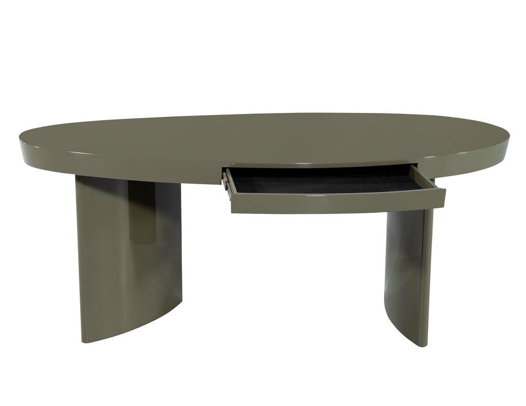 Introducing the modern oval green Cadence writing desk, a stunning piece meticulously crafted by Century Furniture and custom-finished by Carrocel. This exquisite desk features an elegant oval top, beautifully complemented by rounded curved