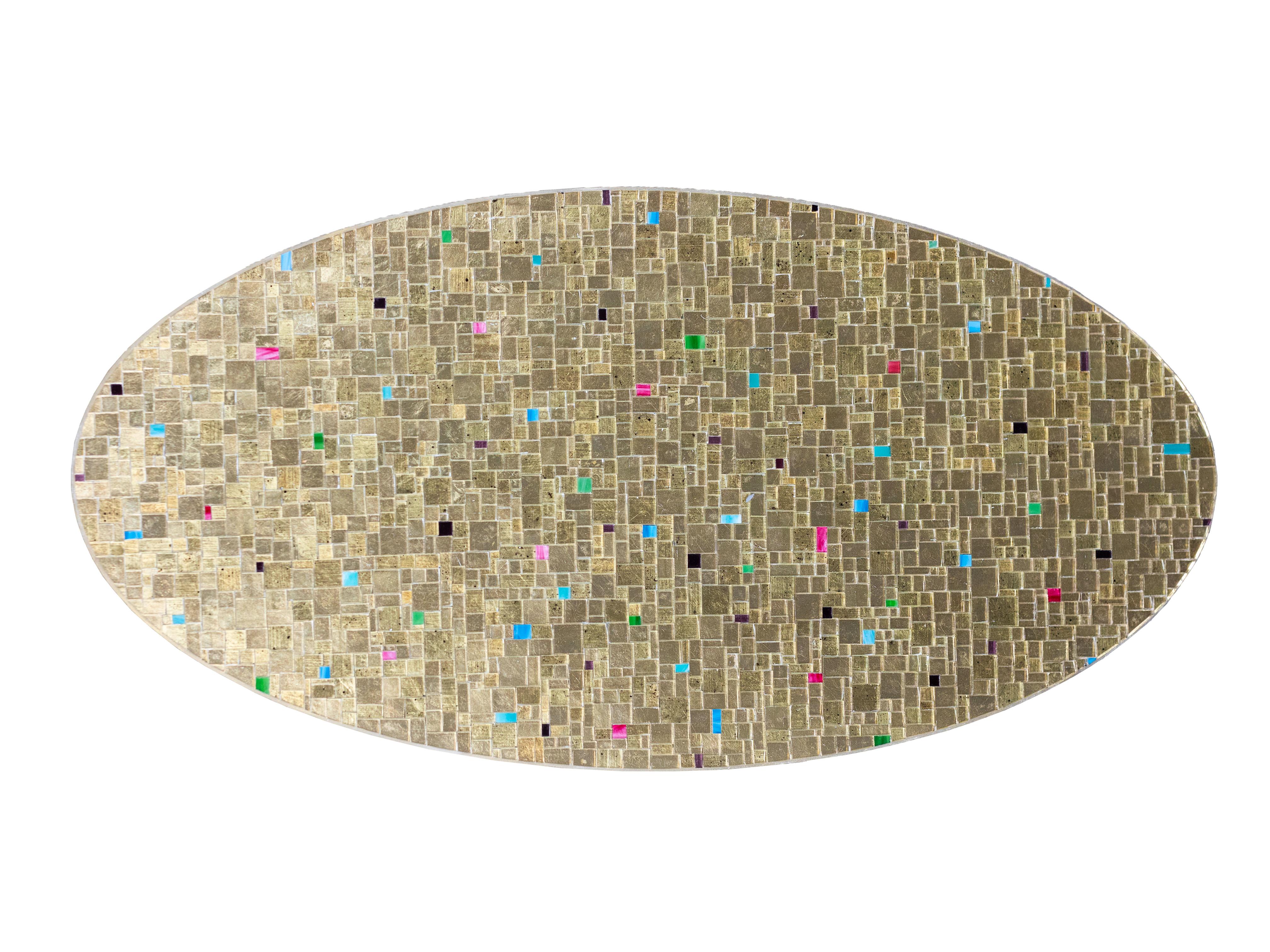 Ercole Home's Modern Oval Moon Gold Mosaic coffee table is a beautifully designed piece that blends modern lines with sophisticated materials. The sleek oval shape is covered in a stunning mosaic pattern, featuring hand-cut gold eglomise a glass