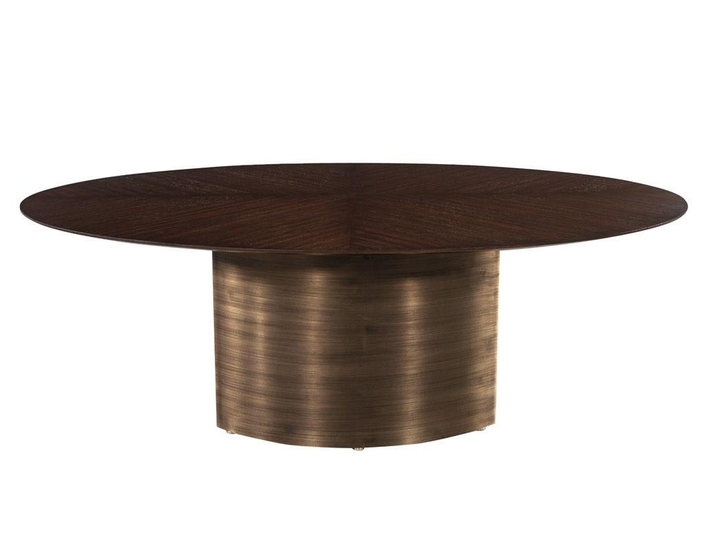 Modern Oval Oak Dining Table with Curved Metal Pedestals. Stunning pattered oak top in a rich dark walnut satin finish. The sleek oval top compliments the beautiful hand crafted curved metal pedestals. Featuring a beautiful antiqued brushed brass