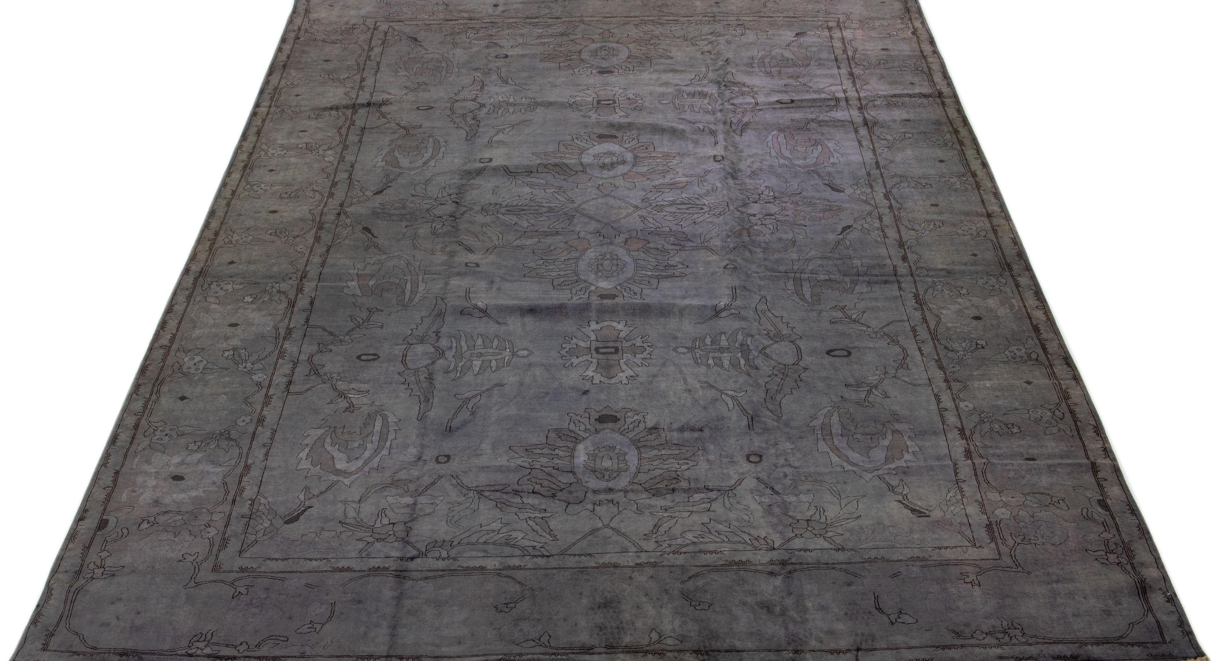 Beautiful modern overdyed hand-knotted oversize wool rug with a gray field. This over-dyed rug has earthy tones in an all-over floral design.

This rug measures: 12'2' x 18'3