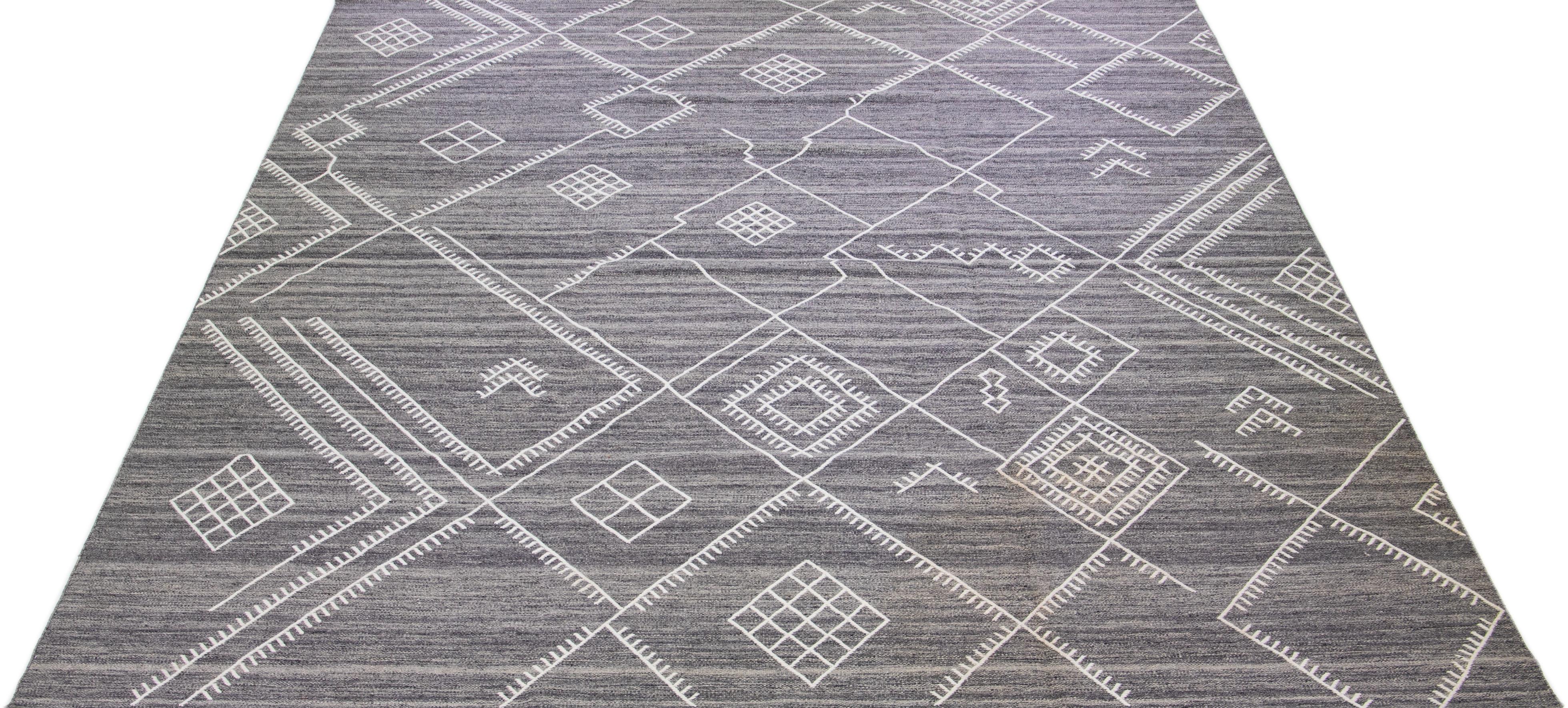 Schöner handgefertigter Kelimteppich aus Wolle mit grauem Feld. Dieser moderne Flachgewebe-Teppich aus unserer Nantucket-Kollektion hat weiße Akzente und ein wunderschönes, geometrisches Küstendesign.

Dieser Teppich misst: 12'7