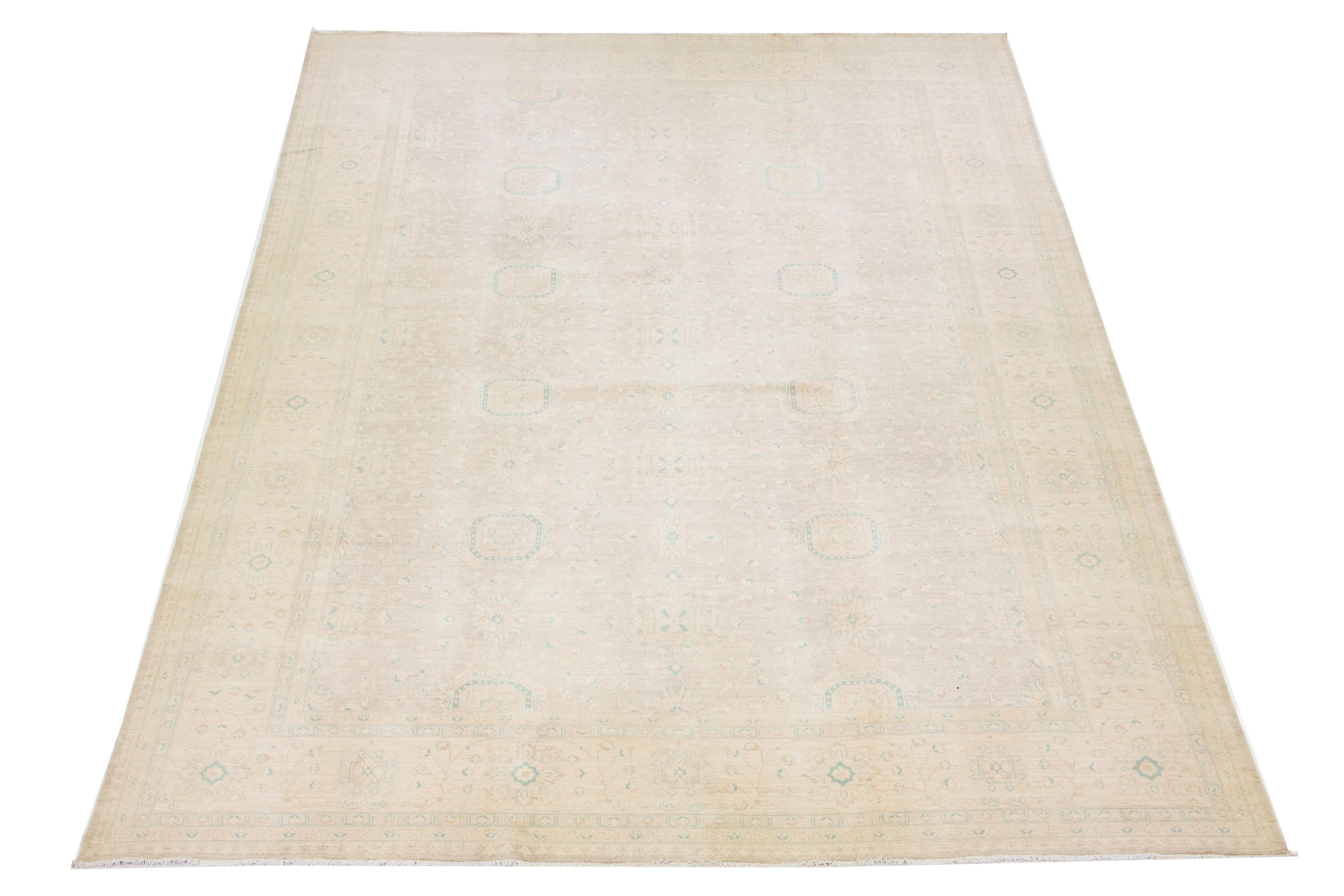 Beautiful modern Oushak hand-knotted wool rug with a beige color field. This Piece has brown and green accent colors in a gorgeous all-over floral design.

This rug measures: 12'1
