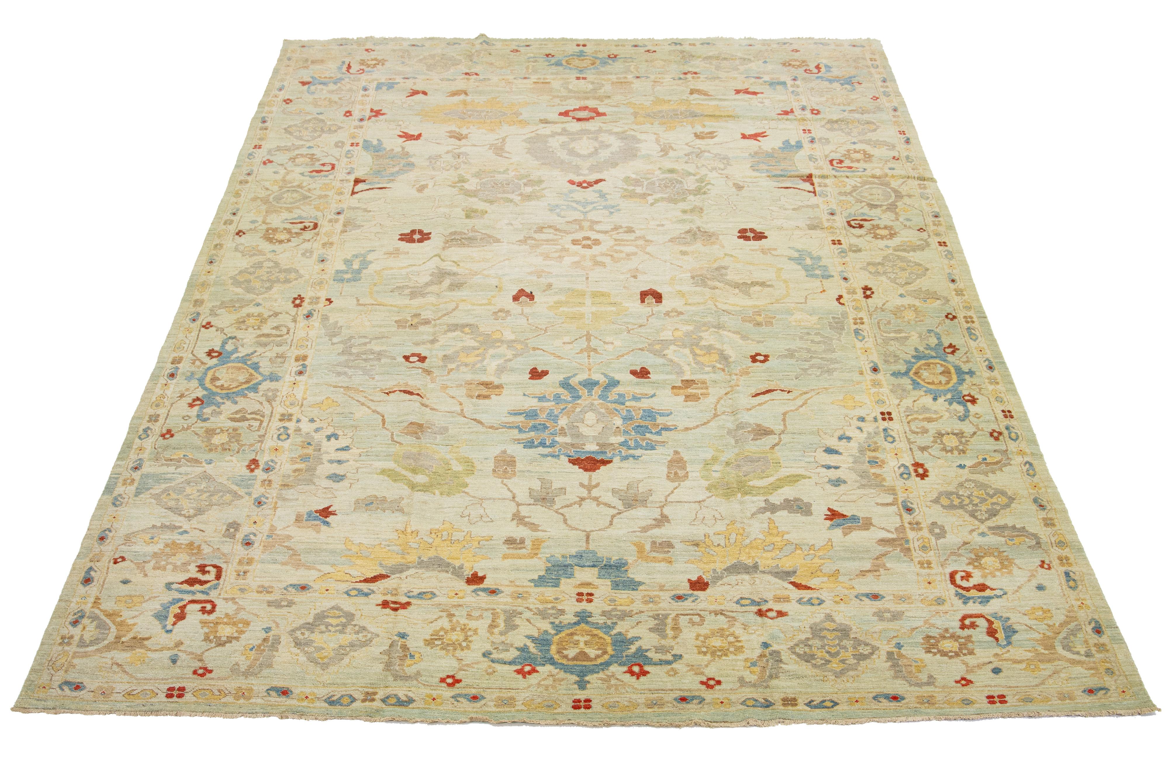 This is a beautiful contemporary Sultanabad Oversize rug, handcrafted using knotted wool. It features a light blue and beige field with multicolor accents in an all-over design. 

This rug measures 12' x 18' 6