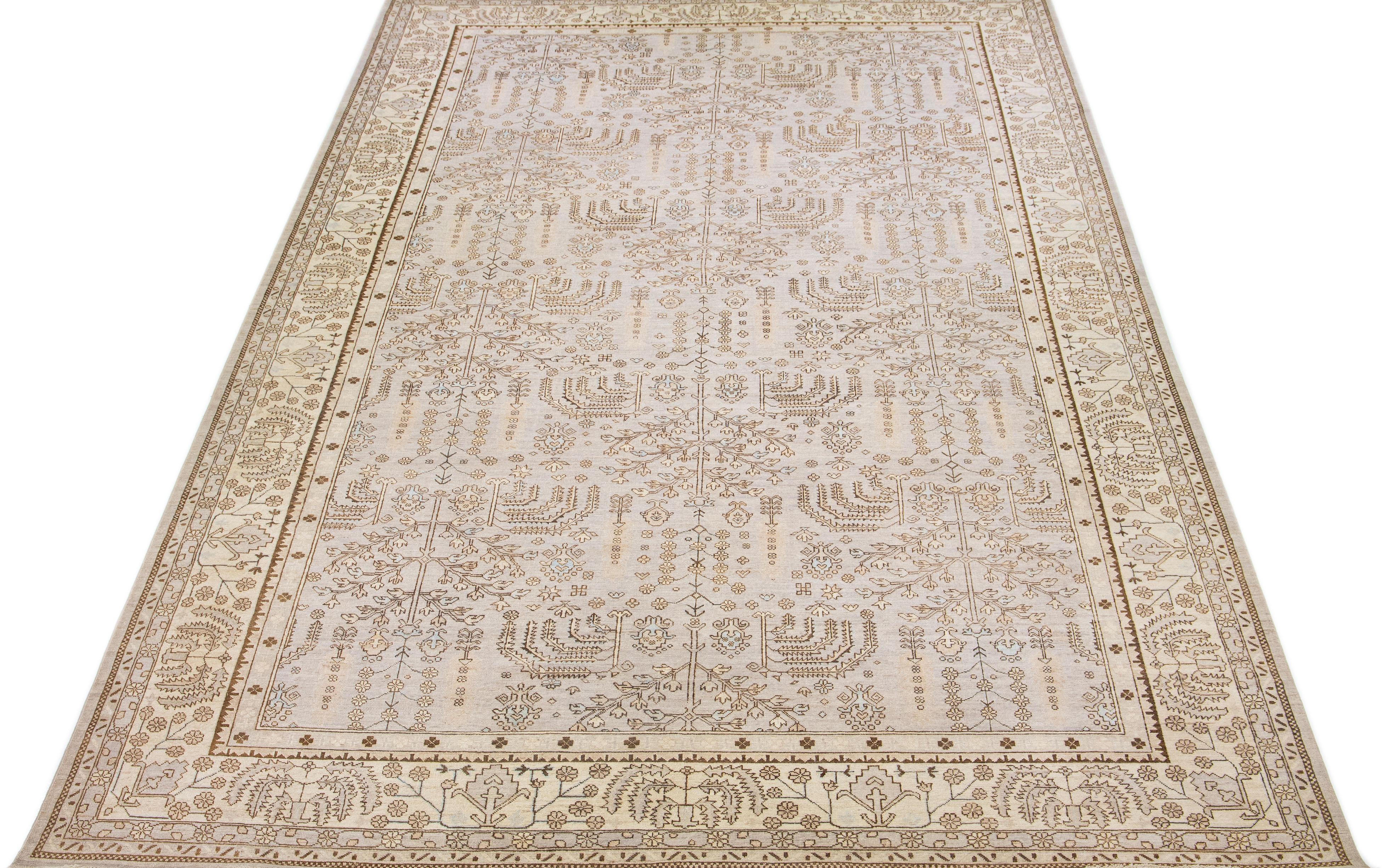 Beautiful contemporary Oushak hand knotted wool rug with a beige field. This Oushak rug has a scattered brown and blue spray of vine scroll designed frame and an all-over geometric floral design. 

This rug measures 11'10