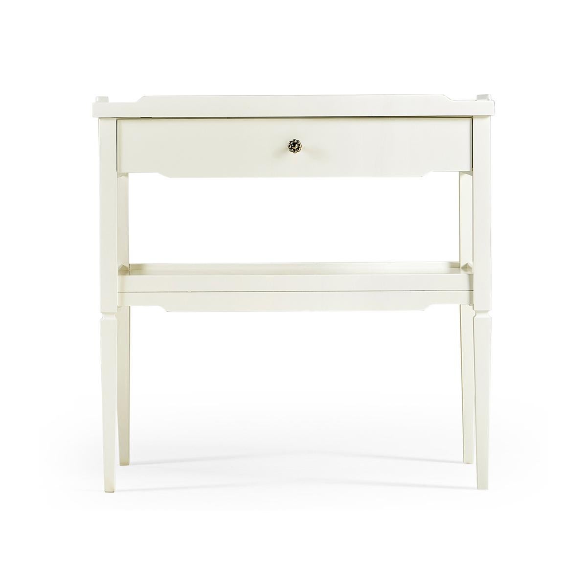 Modern Painted side table with an off white lacquered finish, with a lipped top that doubles as a pull out tray, single drawer lined with a zany blue and white print, power supply access and cord management and a lower shelf for oversized items.