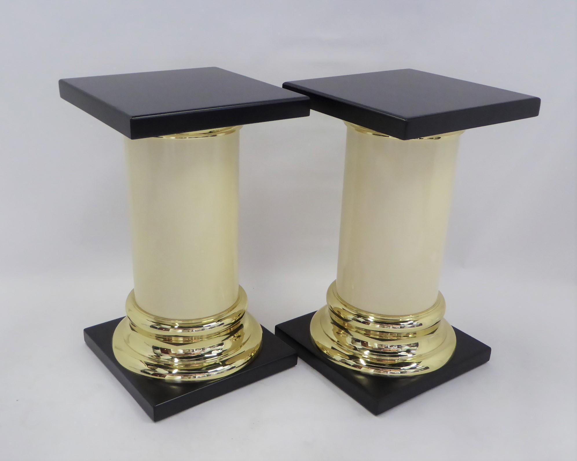 A Mid-Century Modern Mastercraft pedestal or side table with a simple Roman Tuscan column design in the manner of Karl Springer. Featuring a smooth cylindrical ivory colored resin (or ABS plastic) shaft with solid brass capital and base terminating