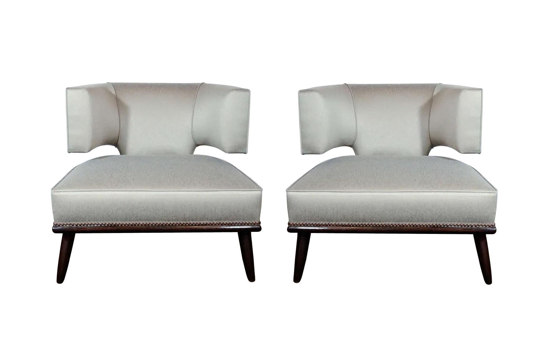 Ein fabelhaftes Paar skulpturaler Loungesessel mit klaren Linien, circa 1950er Jahre. Der fachmännisch gefertigte Sessel ist eine Neuinterpretation des klassischen Pantoffelstuhls mit seiner flachen Klismos-Form, die den Sitzenden umhüllt und
