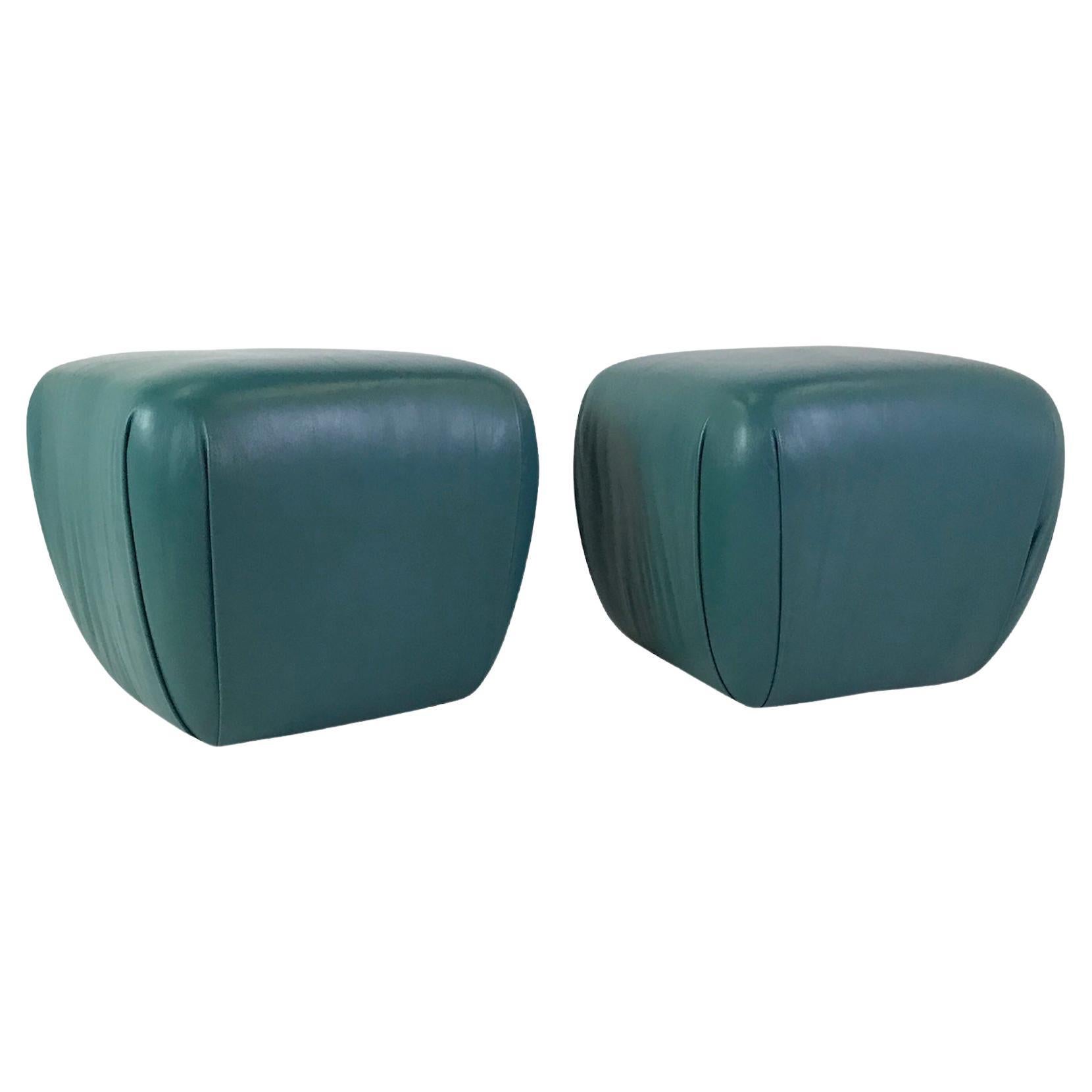 Pair of 1980s teal color leather ottomans by Hancock & Moore for the legendary Naples, Florida design firm Holland Salley, Inc. With a draped design, they slope down, becoming narrower at the bottom. Very faint marks to the leather on one ottoman,