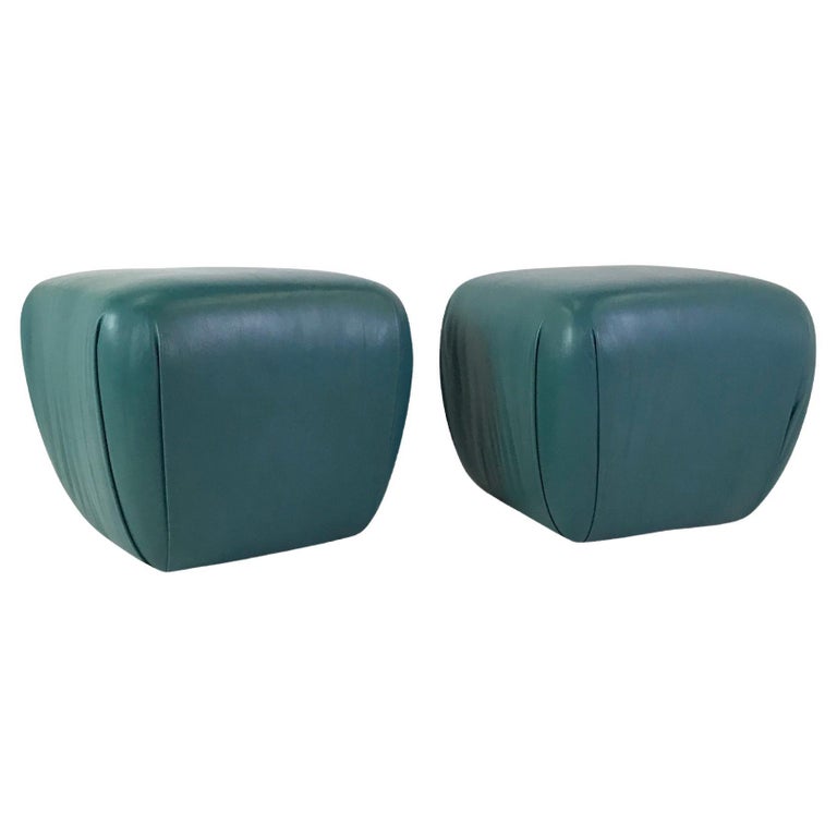 Pair of 1980s teal color leather ottomans by Hancock & Moore for the legendary Naples, Florida design firm Holland Salley, Inc. With a draped design, they slope down, becoming narrower at the bottom. Very faint marks to the leather on one ottoman,