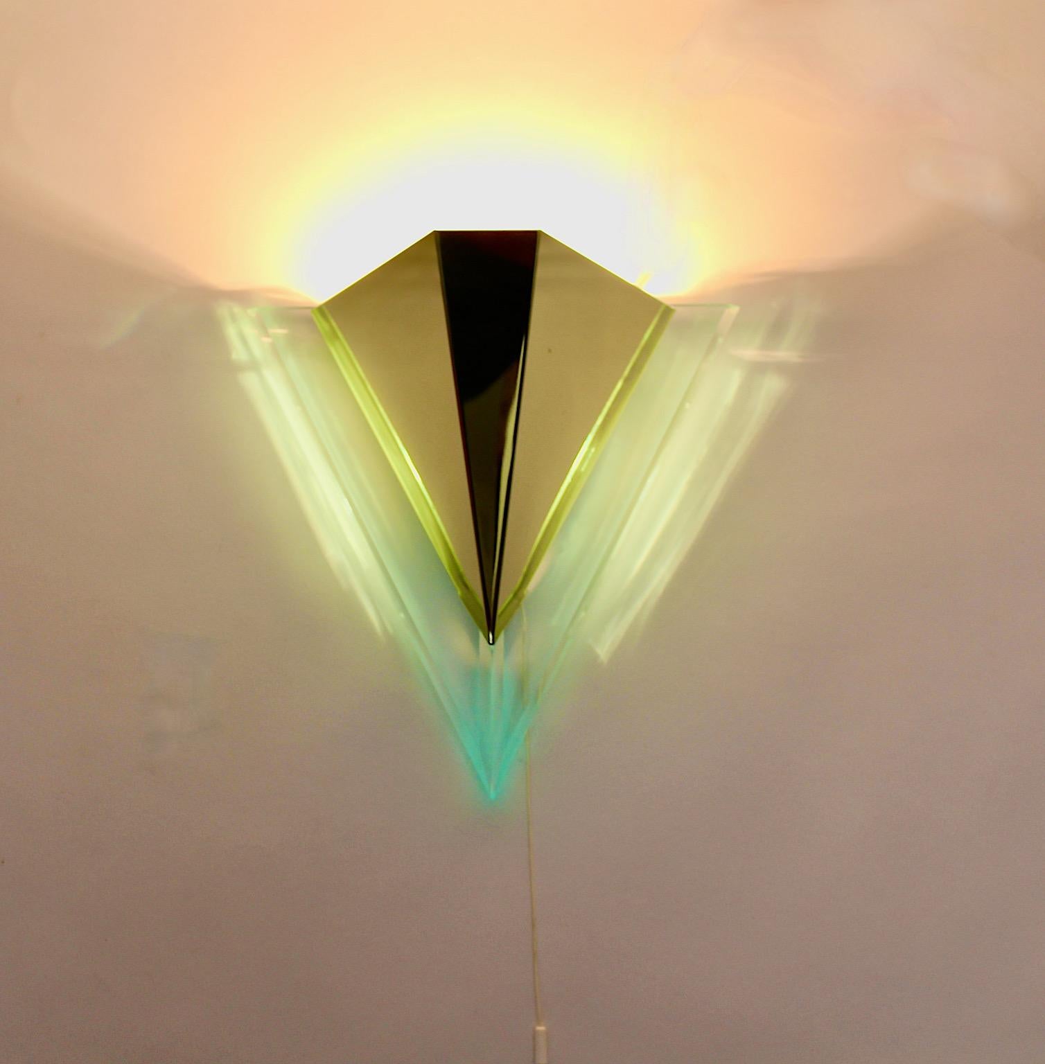 Moderno par de apliques vintage en forma de triángulo de lucite y metal de la década de 1990 en Alemania.
Un marco de lucita subraya la forma triangular con cuerpo de metal latonado .
Puedes conectar la iluminación directamente o utilizarla con un