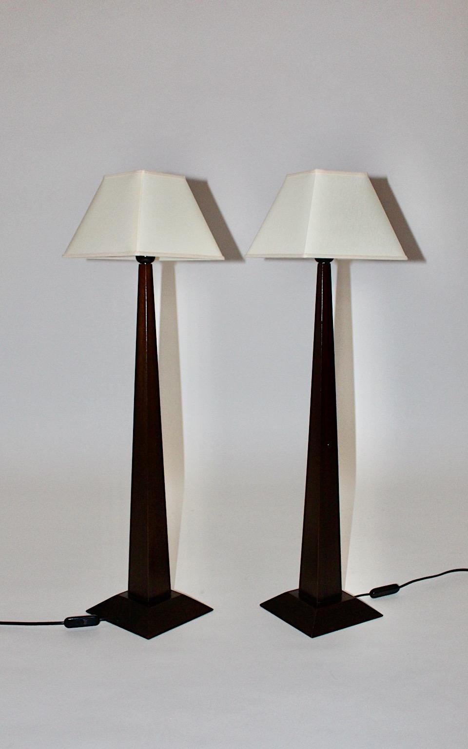 French modern pair of obelisk table lamp by Atelier Lumen Creation Luc Rabault 1980s, France from stained beech wood with rectangular lamp shades in butter cream color.
The color different between dark wood stem and the light colored lamp shades
