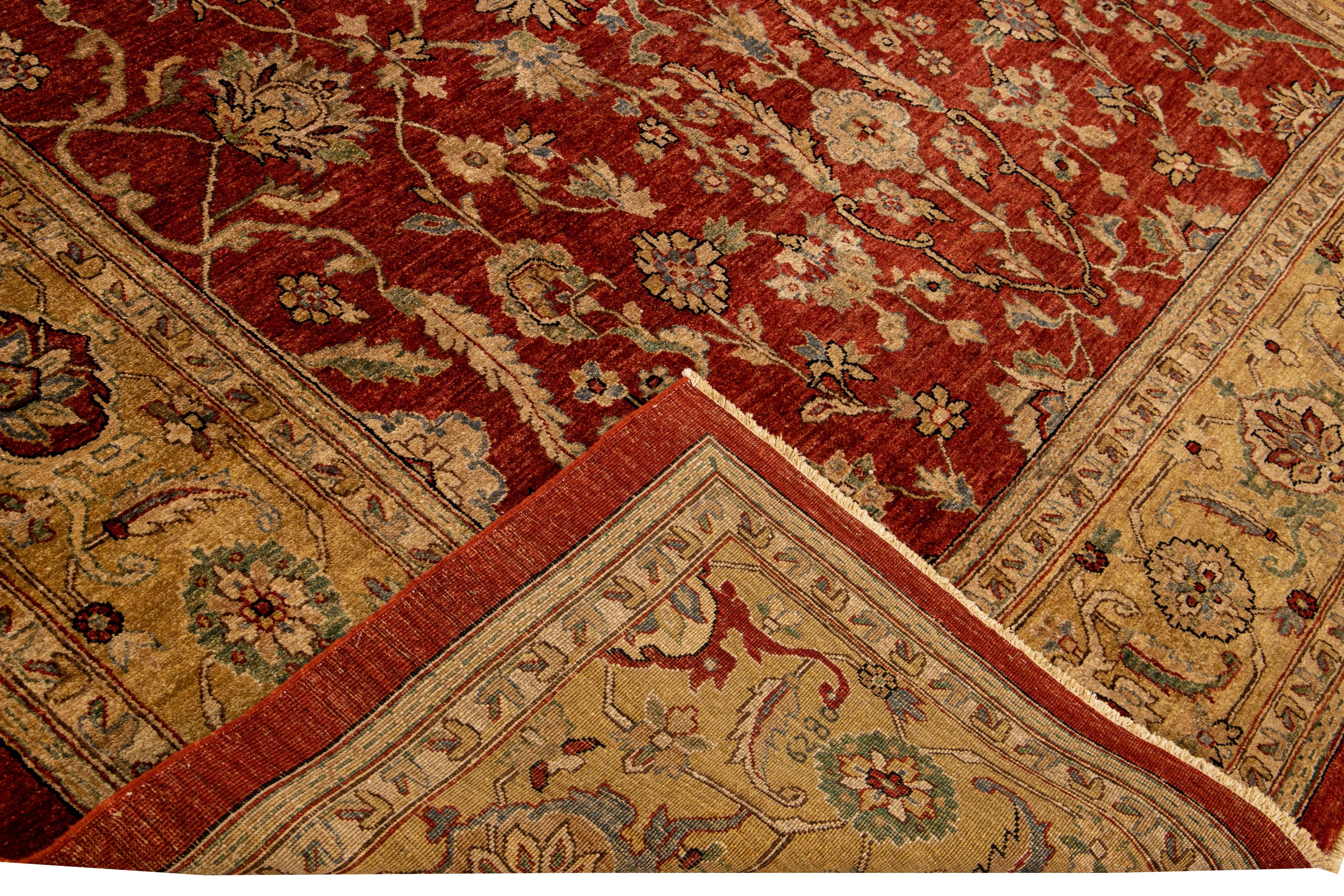 Magnifique tapis en laine Paki Peshawar noué à la main avec le champ rouge. Ce tapis moderne présente des accents de beige, de bleu et de vert dans un magnifique motif de rinceaux de vigne classique et de palmettes.

Ce tapis mesure : 9' x
