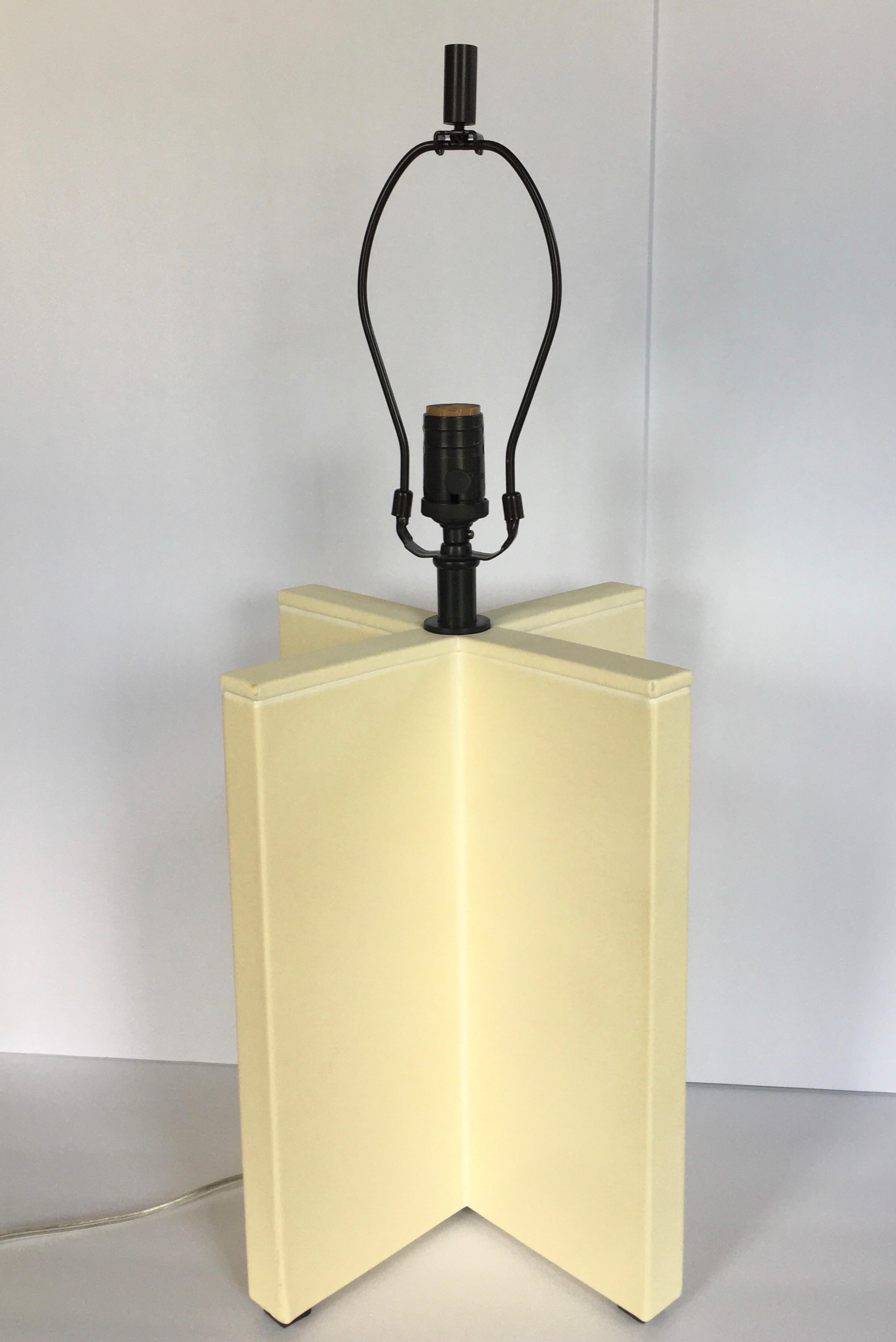 Modern crosspiece cream goatskin table lamp with bronze tone hardware by J. Randall Powers for Visual Comfort Lighting. Lamp shade not included.

Measures: Height to finial 26.5 inches.
Height to socket 19 inches.