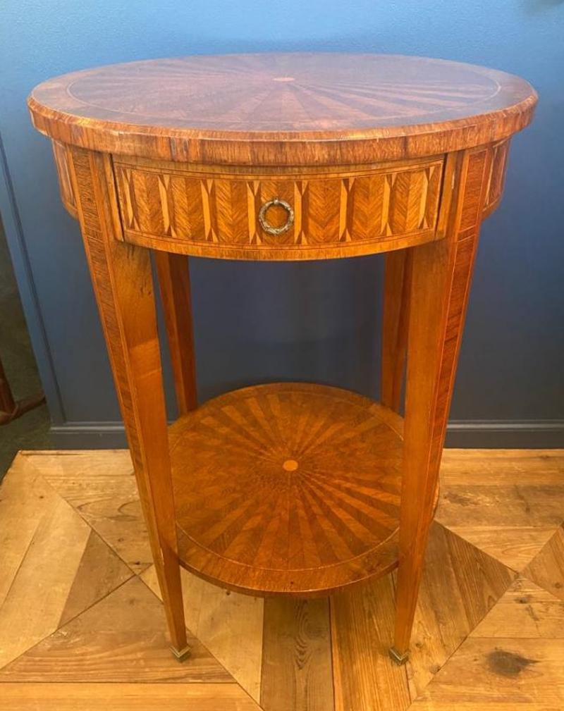 Parquetry inlaid mahogany side table with circular top above a conforming frieze with drawer. Square tapering legs with cap feet and under tier. Modern, early 2000s. Measures: 29