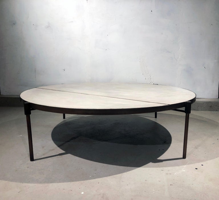 This patinated brass and concrete coffee table is also available in a bright brass / natural brass. 
The concrete is a composite , the texture of the top varies and has beautiful pitting and markings. Finished in a clear satin finish that allows