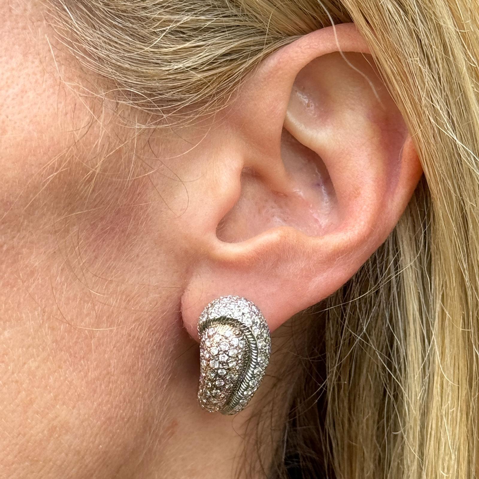 These modern diamond earrings feature a striking design crafted from 18-karat two-tone gold. The elegant style is adorned with  300 round brilliant pave-set diamonds, adding a continuous shimmer across the surface of the earrings. The diamonds weigh