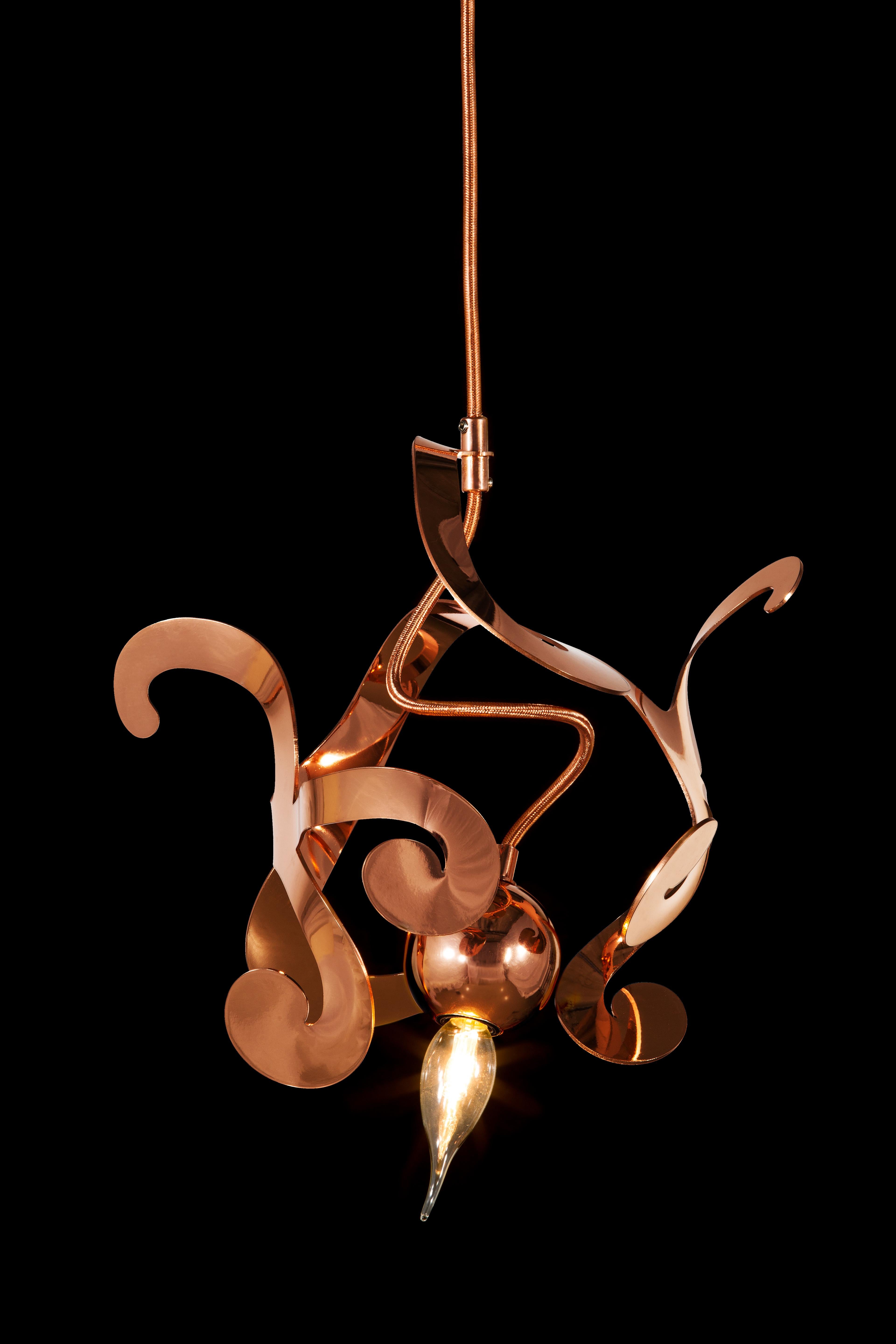 The Kelp modern pendant in a copper finish, designed by William Brand, is a free and playful organic lighting sculpture in the collection of Brand van Egmond. The seemingly randomness of the lighting sculpture, yet carefully arranged ornaments will