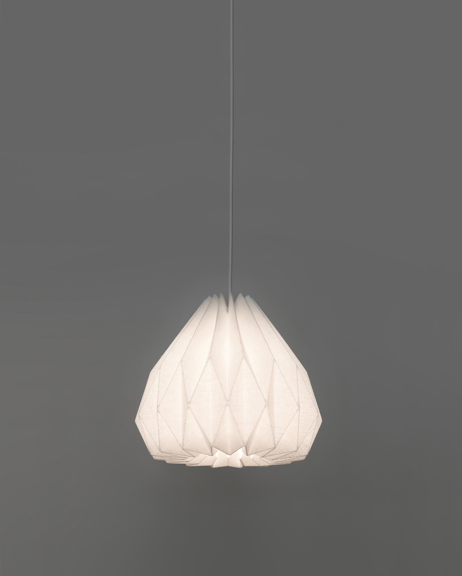 The modern-style pendant lamp will bring an interesting and functional work of art to your interior. The origami-inspired lampshade is made of laminated linen fabric providing bright, yet soft ambient light and showing the beautiful texture of the