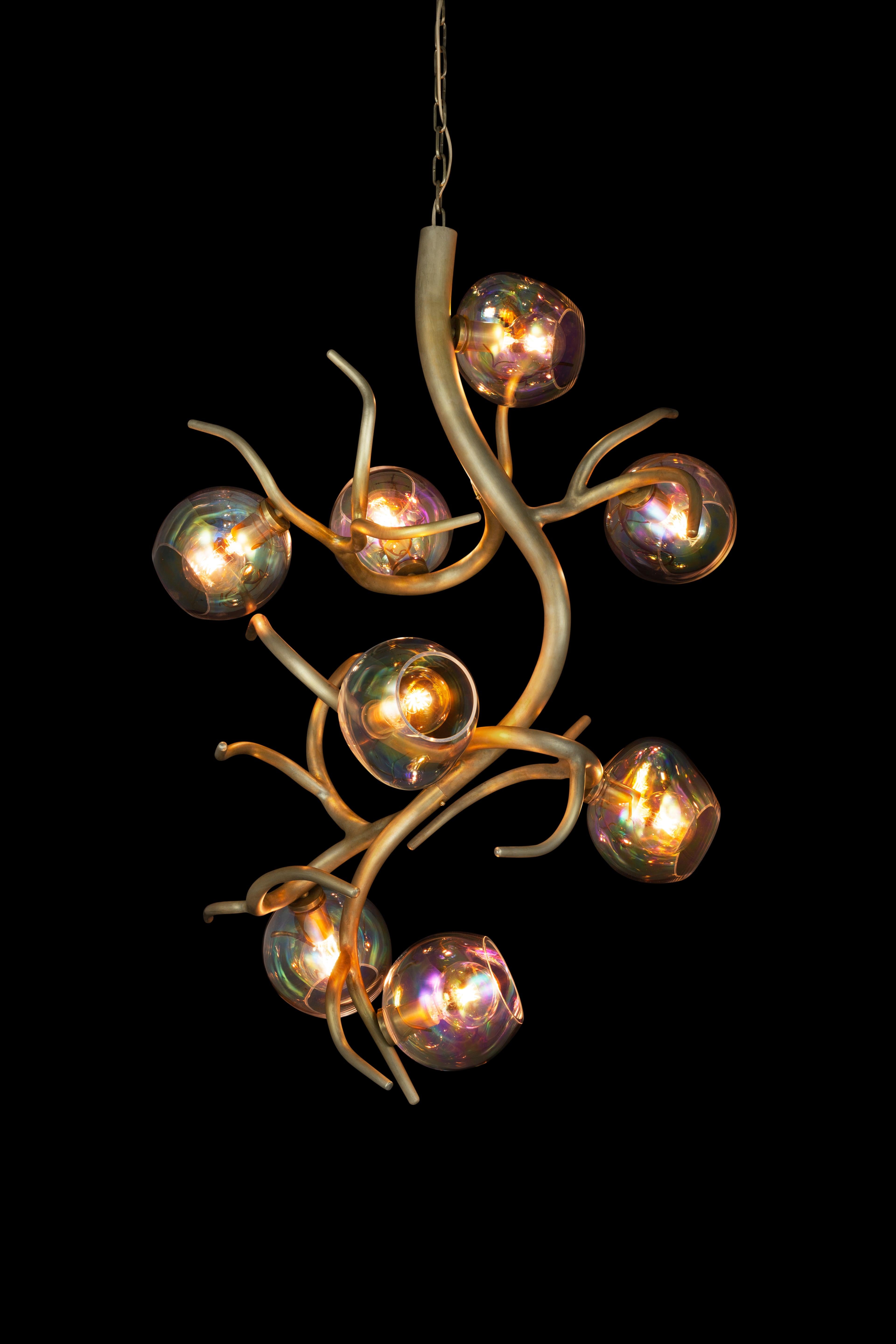 The Ersa, a modern chandelier vertical in a brass burnished finish with iridescent glass spheres, is designed by William Brand, founder of Brand van Egmond. Whether arranged in an entrance, a hallway or staircase, or other high space, the Ersa