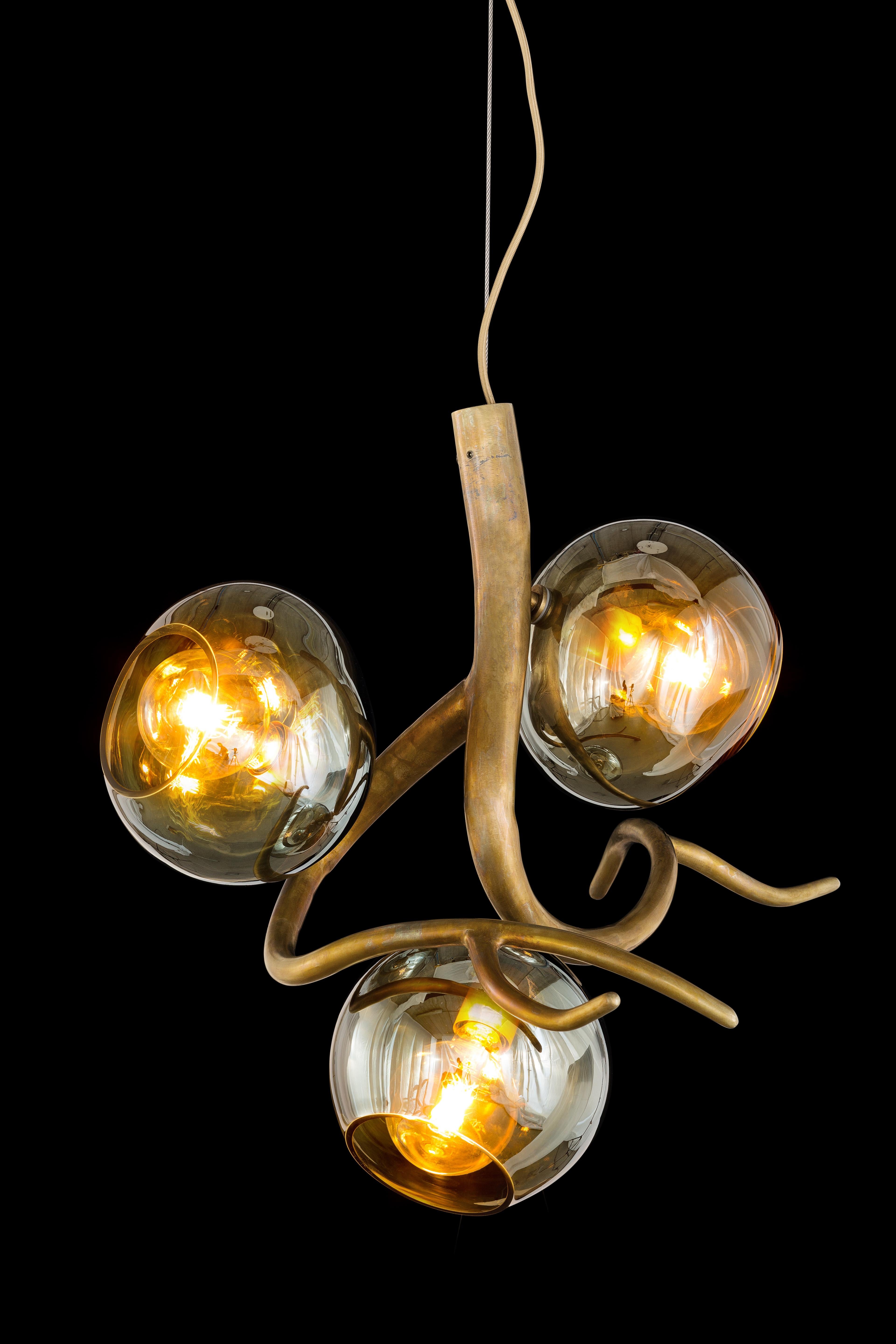 Named after the ancient Greek Goddess of dew, this Ersa modern pendant in a brass finish with iridescent glass spheres offers light with a sculptural touch for every possible position or space. The Ersa pendant is available with one, two, or three