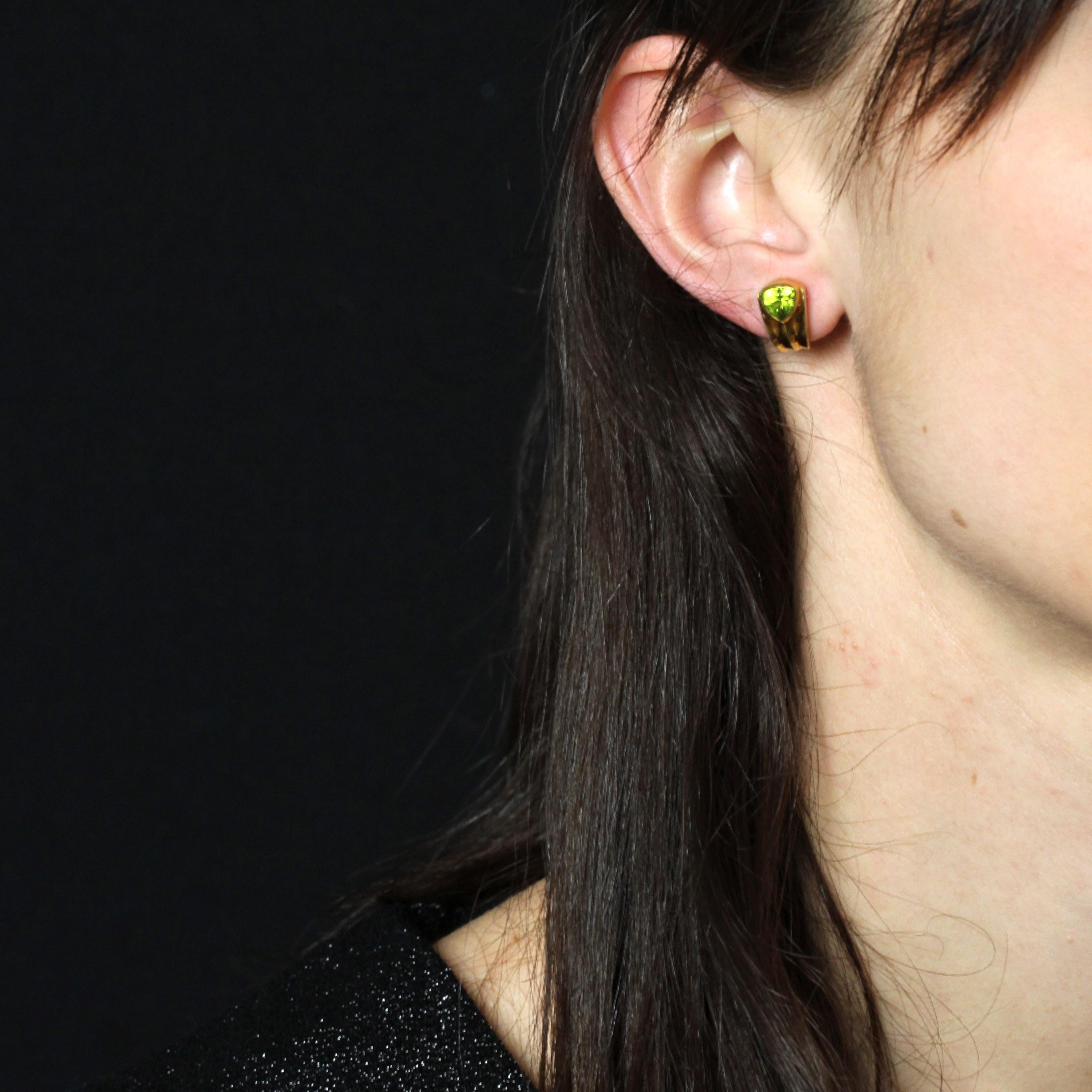 For pierced ears.
Earring in 18 karat yellow gold, eagle head hallmark.
These vintage gold earrings feature a half-creole design, adorned at the top with a closed-set peridot. The fastening system is an Alpa disc.
Height : 15 mm approximately, width