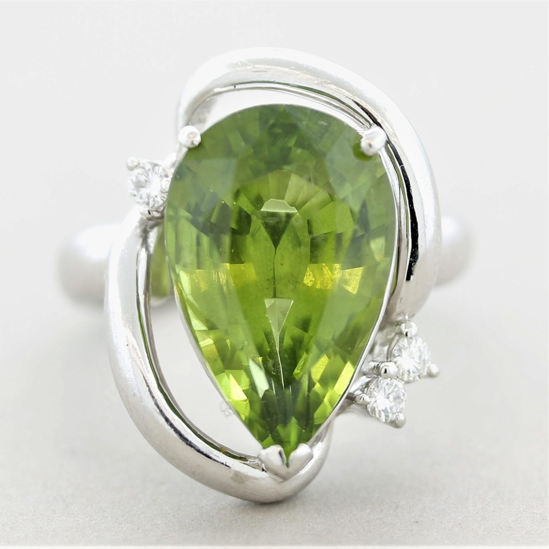 A unique designed platinum ring featuring a large and impressive peridot! The peridot weighs 10.22 carats, has a beautifully proportioned pear-shape and a bright vivid green color. Accented the peridot are 3 round brilliant-cut diamonds weighing