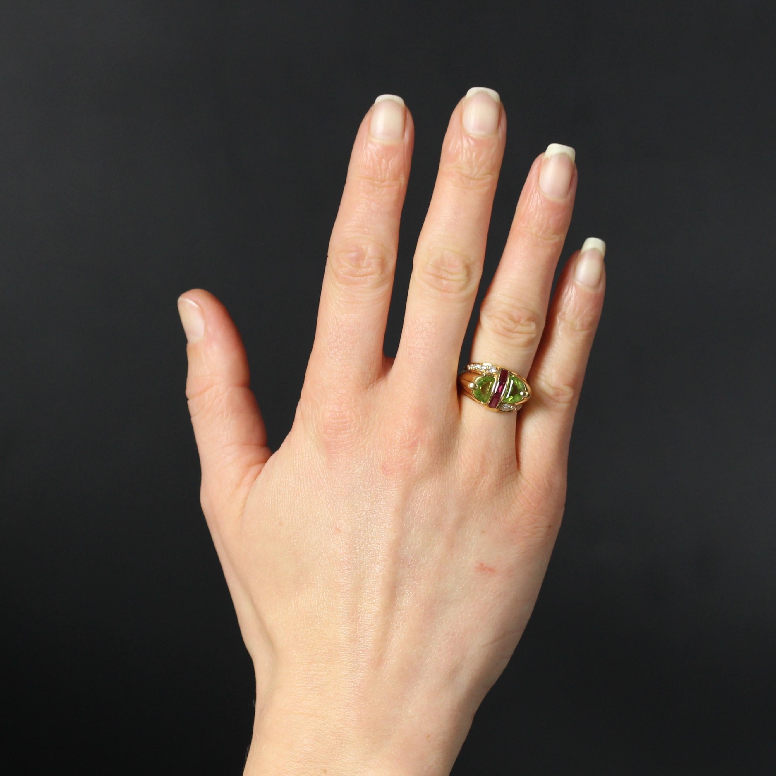 Ring in 18 karat yellow gold, eagle head hallmark.
In the spirit of tank rings, this second-hand gold ring features two half-moon-cut peridots on top and a line of 3 baguette-cut rubies in the center. On either side, asymmetrically set at the start