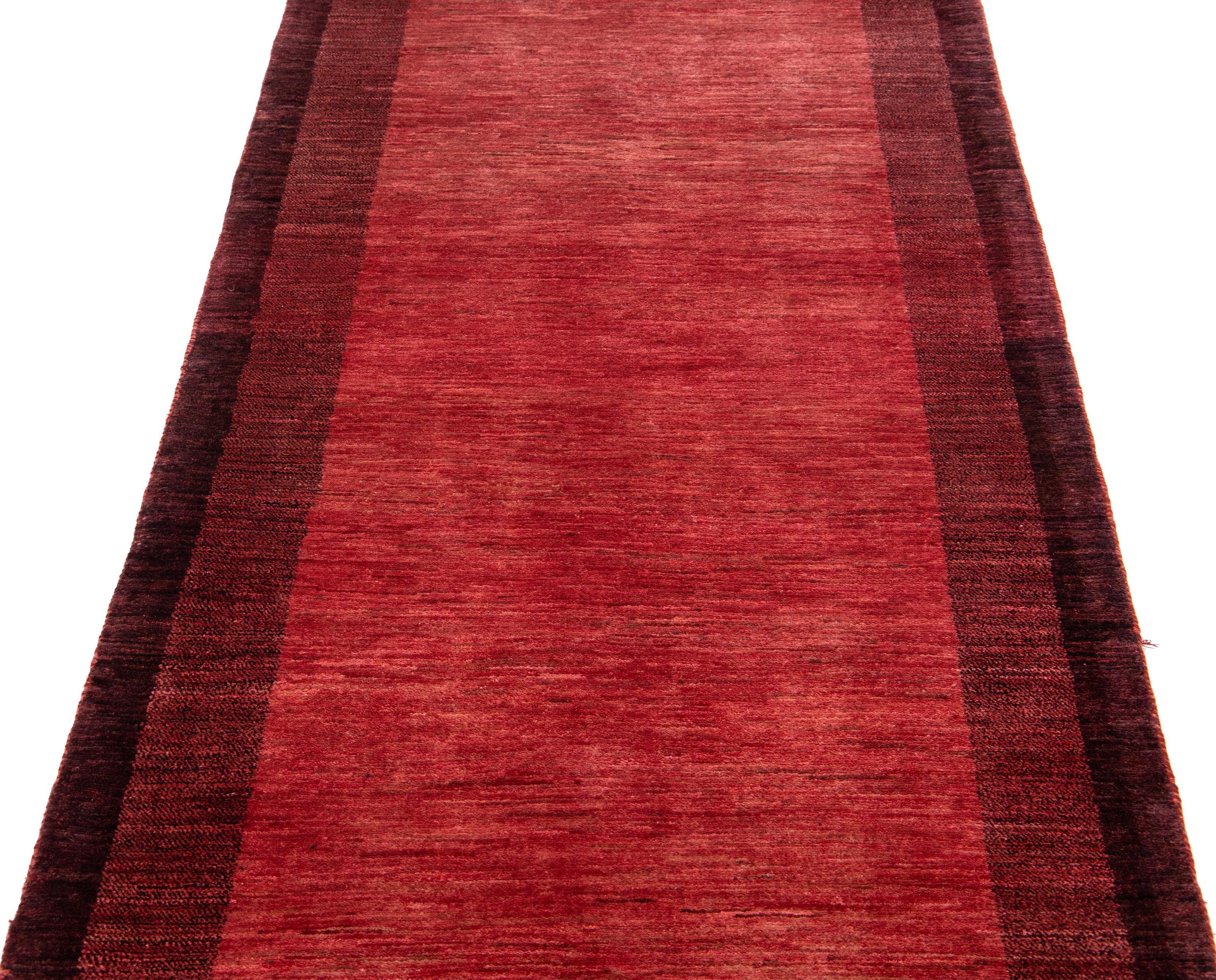 Schöner, moderner, handgewebter Woll-Läufer im Gabbeh-Stil mit rotem Farbfeld. Dieser Perserteppich hat ein wunderschönes minimalistisches Design mit burgunderroten Akzenten.

Dieser Teppich misst: 3'2