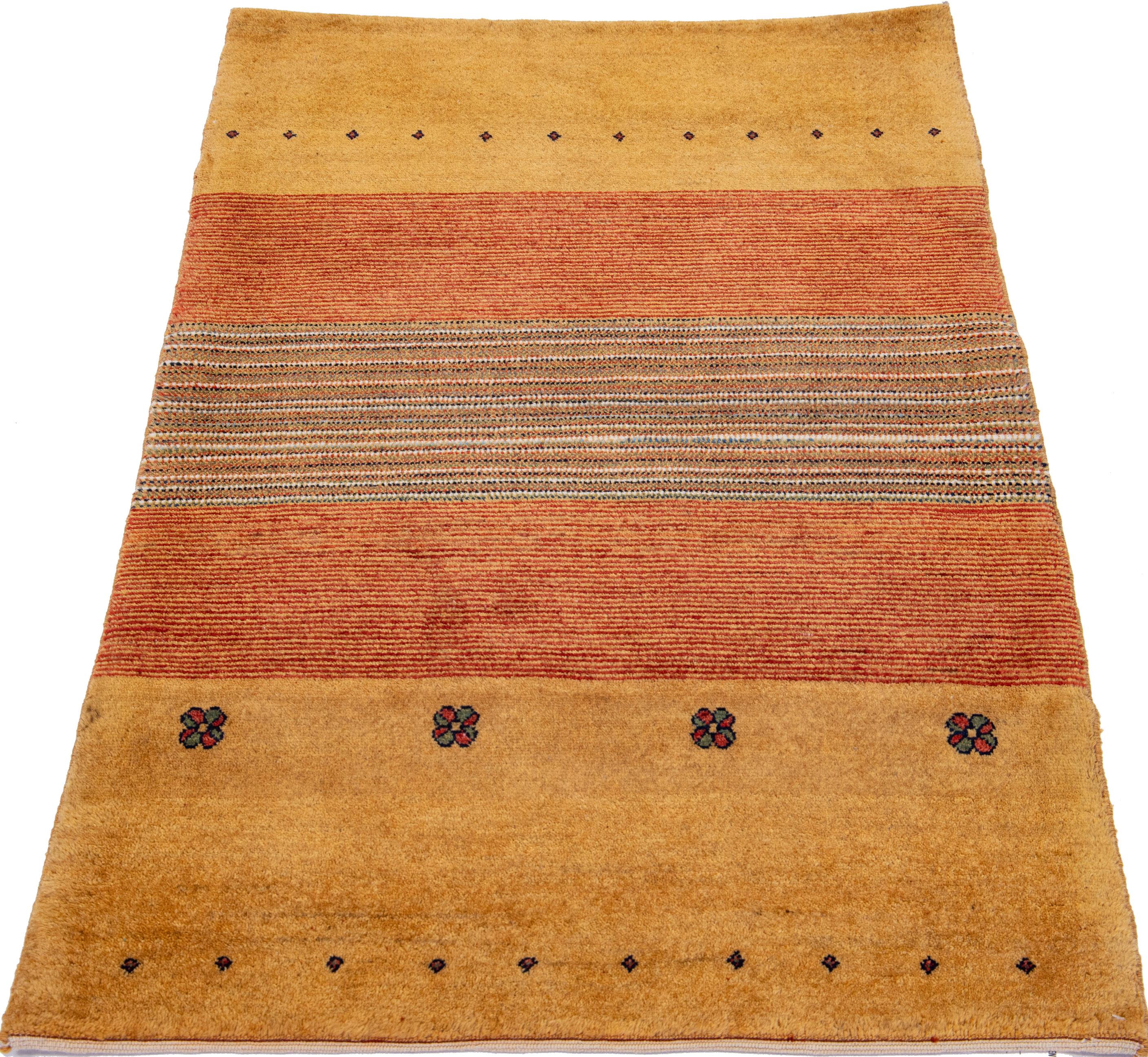 Beautiful modern Gabbeh-style hand-woven wool rug with a tan color field. This Persian rug has a gorgeously geometric design with blue and red accents.

This rug measures: 2'8