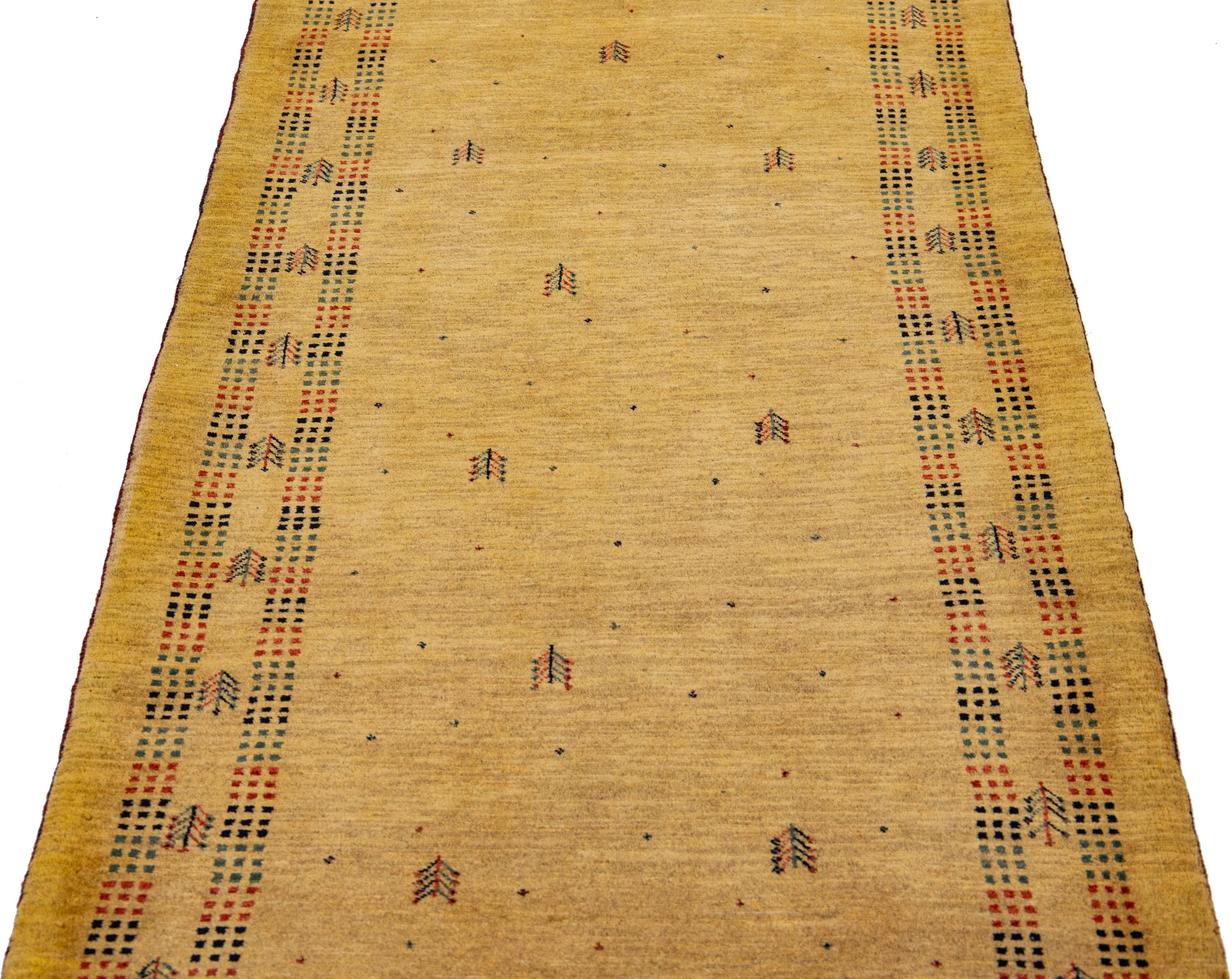 Beautiful modern Gabbeh-style hand-woven wool rug with a tan color field. This Persian rug has a gorgeous multicolor minimalist motif.

This rug measures: 2'10