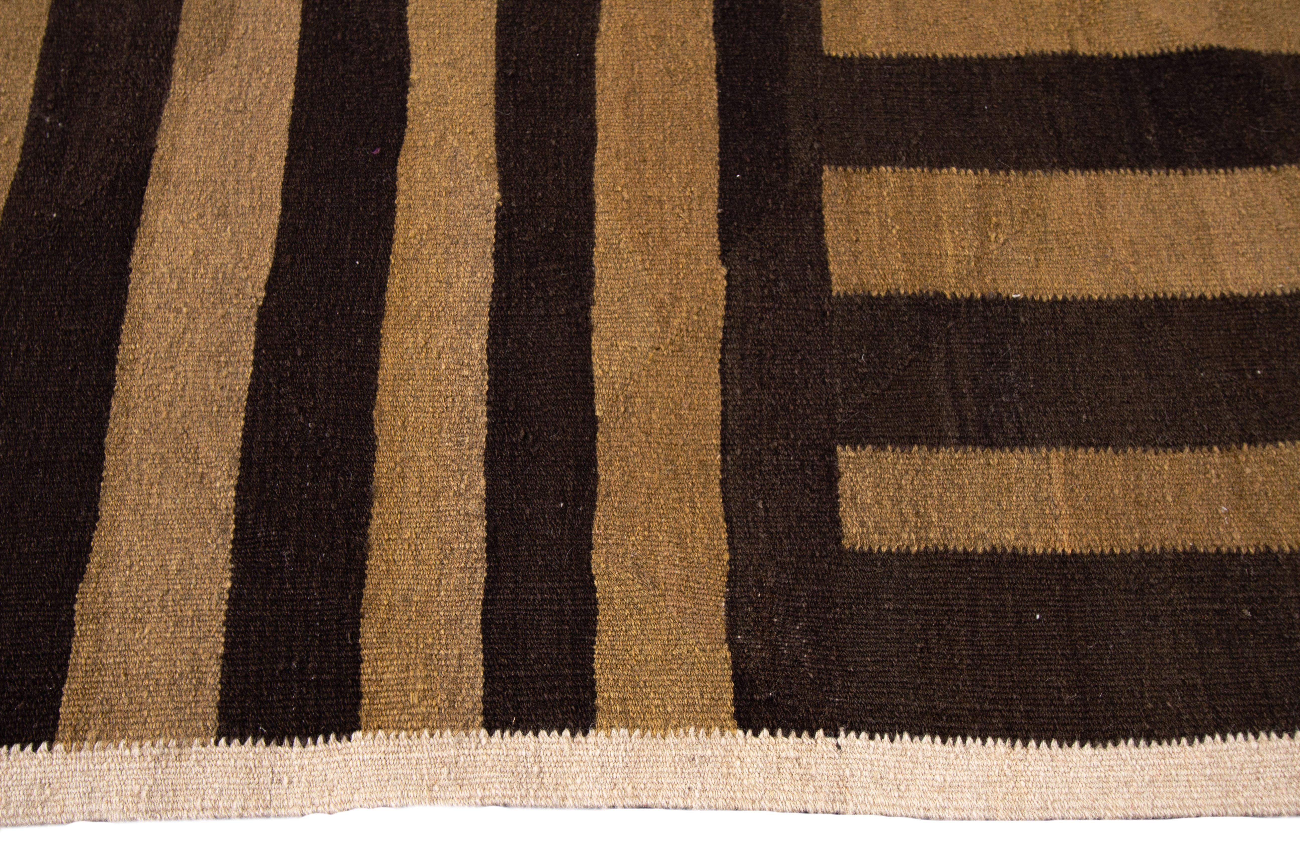 Hand-knotted rug with a lined design on a brown field with beige borders. Measures: 8'7