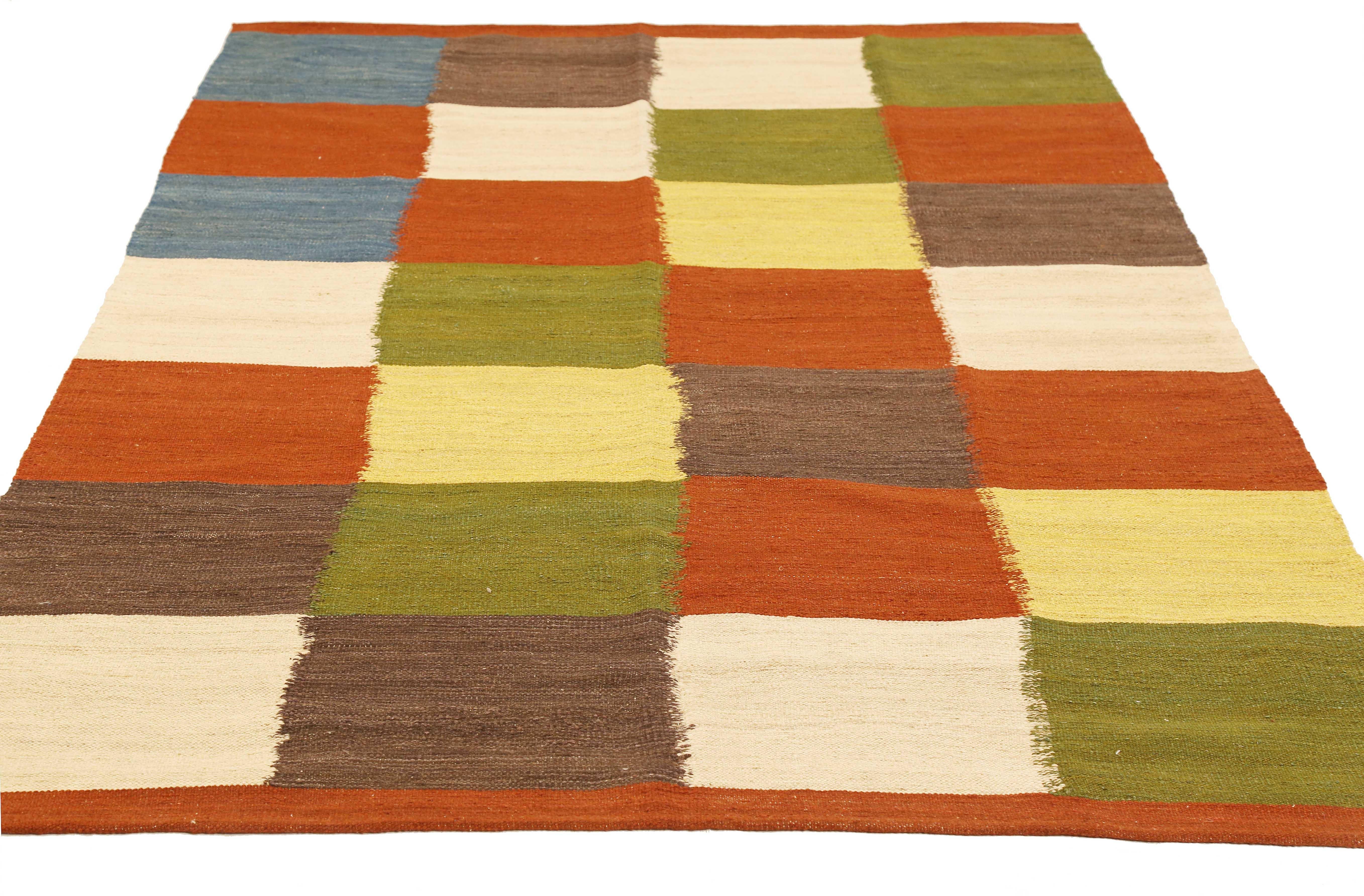 Modern Persian rug handwoven from the finest sheep’s wool and colored with all-natural vegetable dyes that are safe for humans and pets. It’s a traditional Kilim flat-weave design featuring colored squares on an ivory field. It’s a stunning piece to