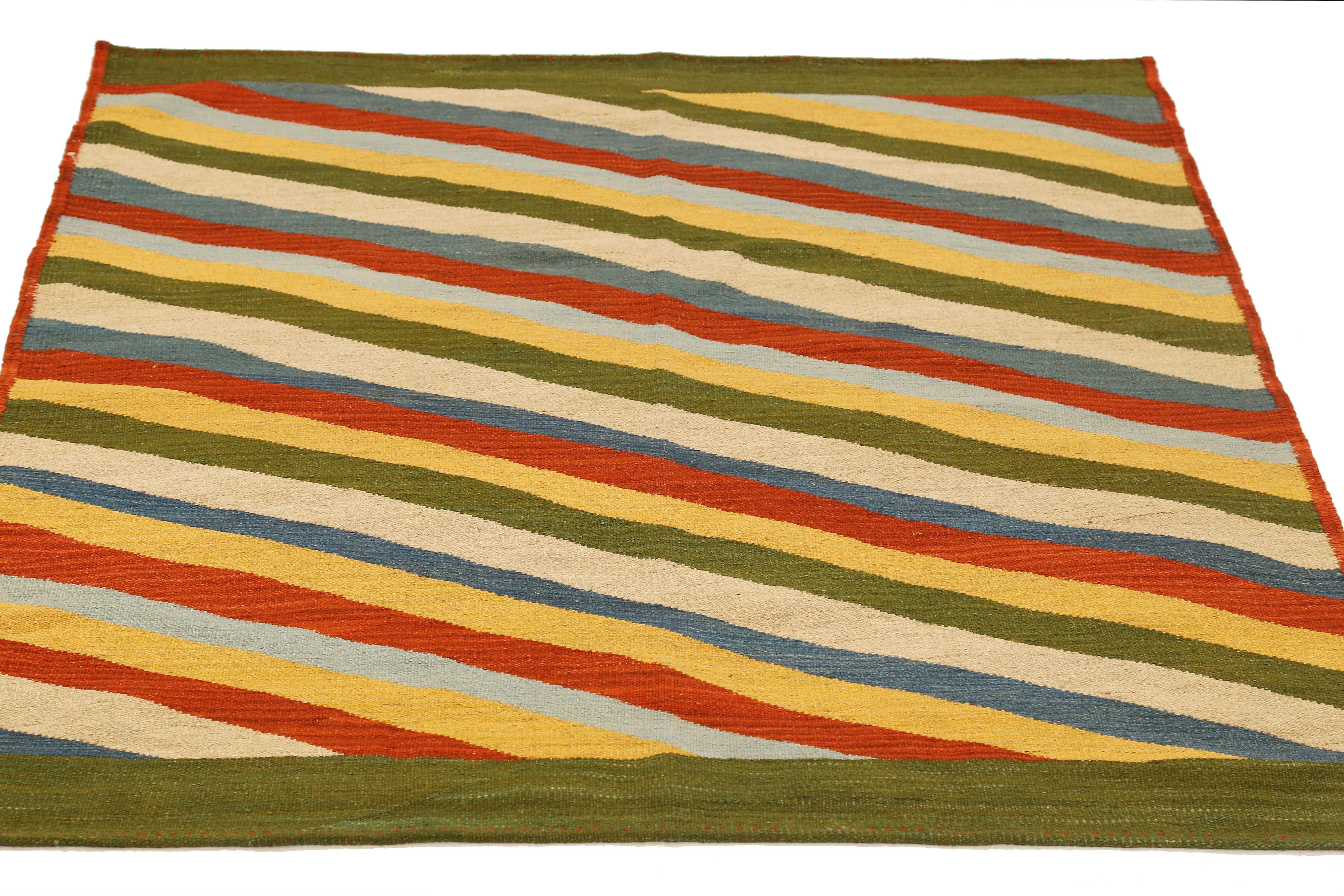 Modern Persian rug handwoven from the finest sheep’s wool and colored with all-natural vegetable dyes that are safe for humans and pets. It’s a traditional Kilim flat-weave design featuring diagonal stripes in various bright colors over a green