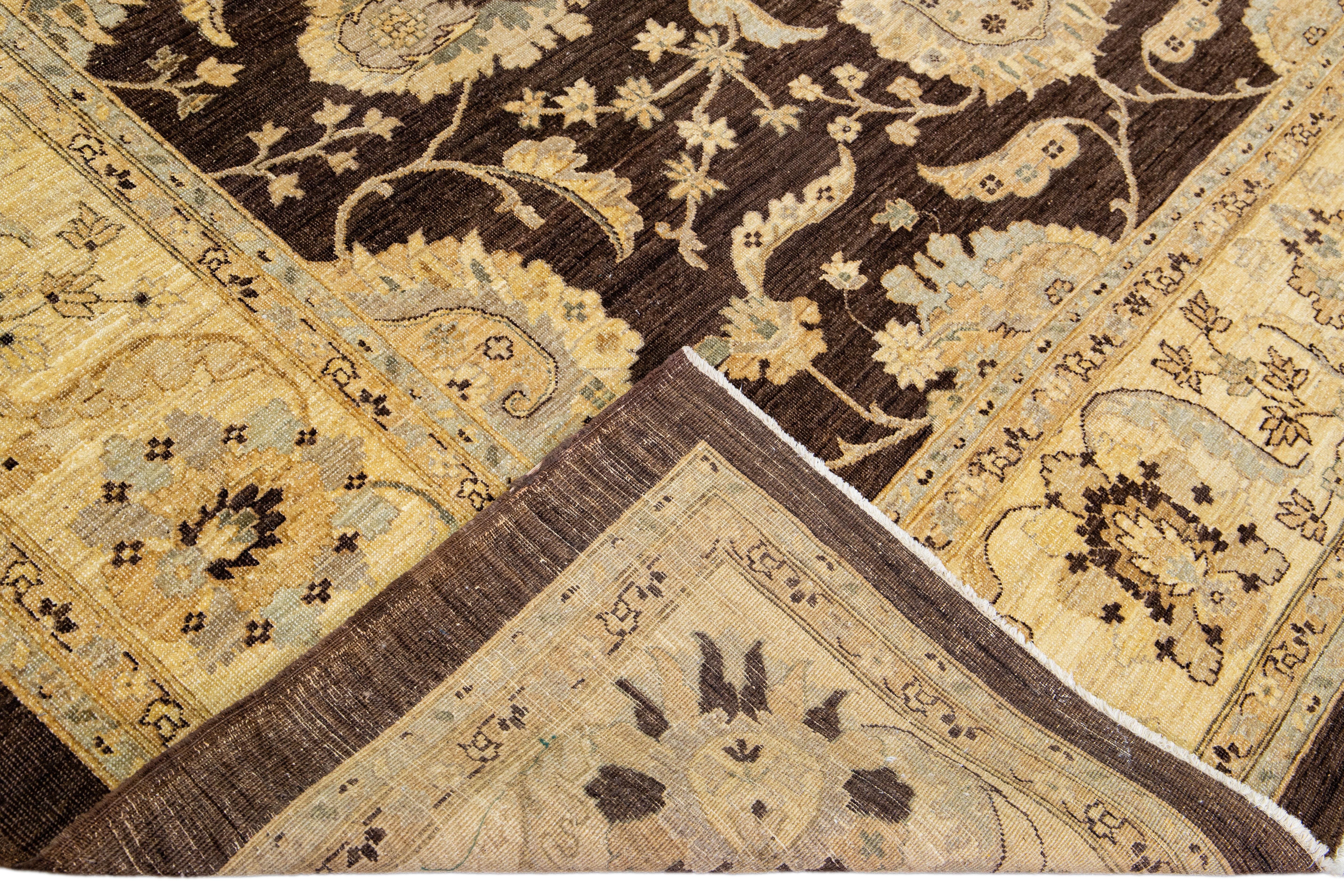 Beautiful oversize Paki Peshawar hand-knotted wool rug with a brown field. This modern rug has gray and golden accents in a gorgeous all-over Classic vine scroll and a palmettes motif.

This rug measures: 9'11'' x 13'6