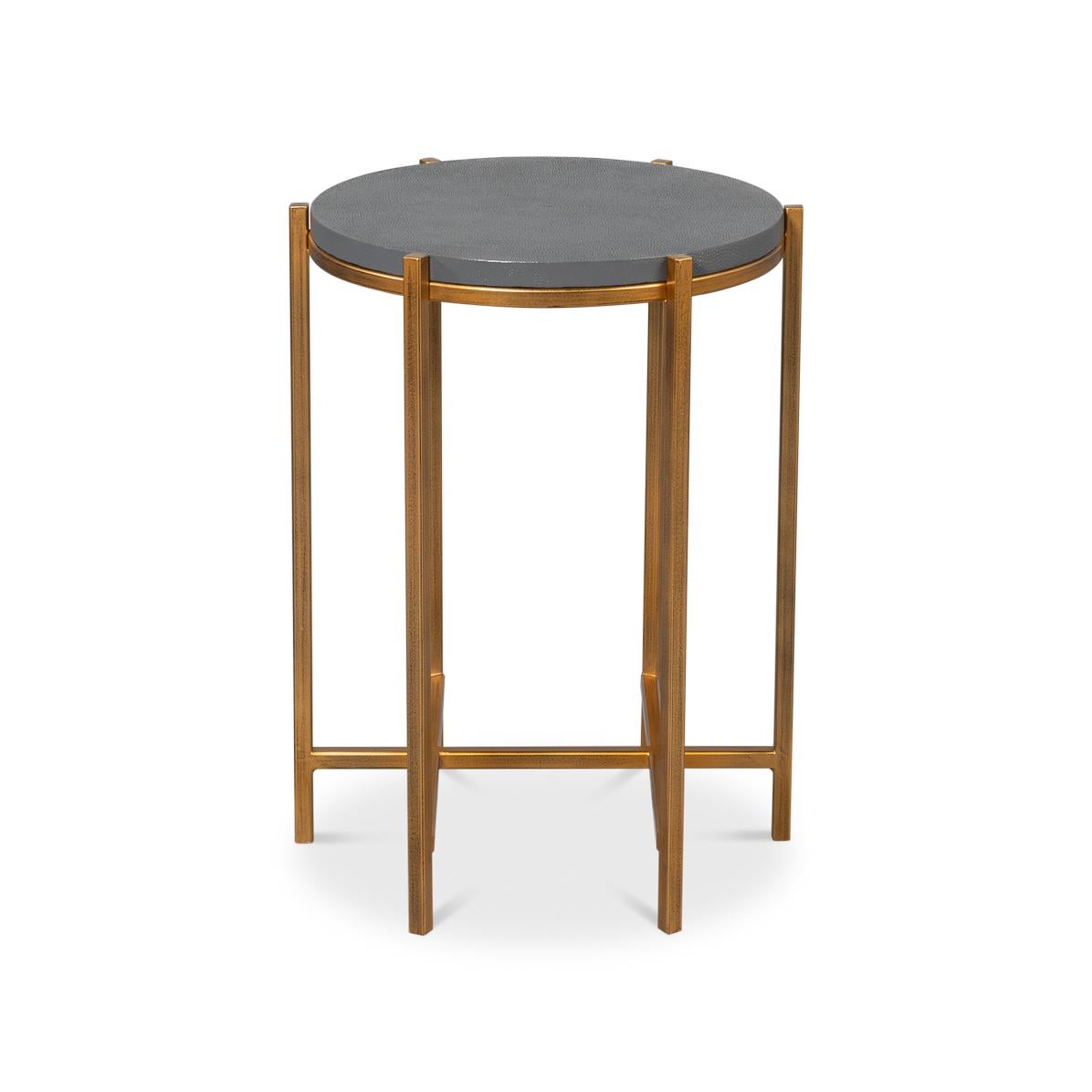 Where contemporary design meets sophisticated luxury. The table features a stunning leather-wrapped shagreen embossed round top in an elegant gray hue, creating a sleek and stylish surface.

Supported by a unique six-legged gilt metal base with a