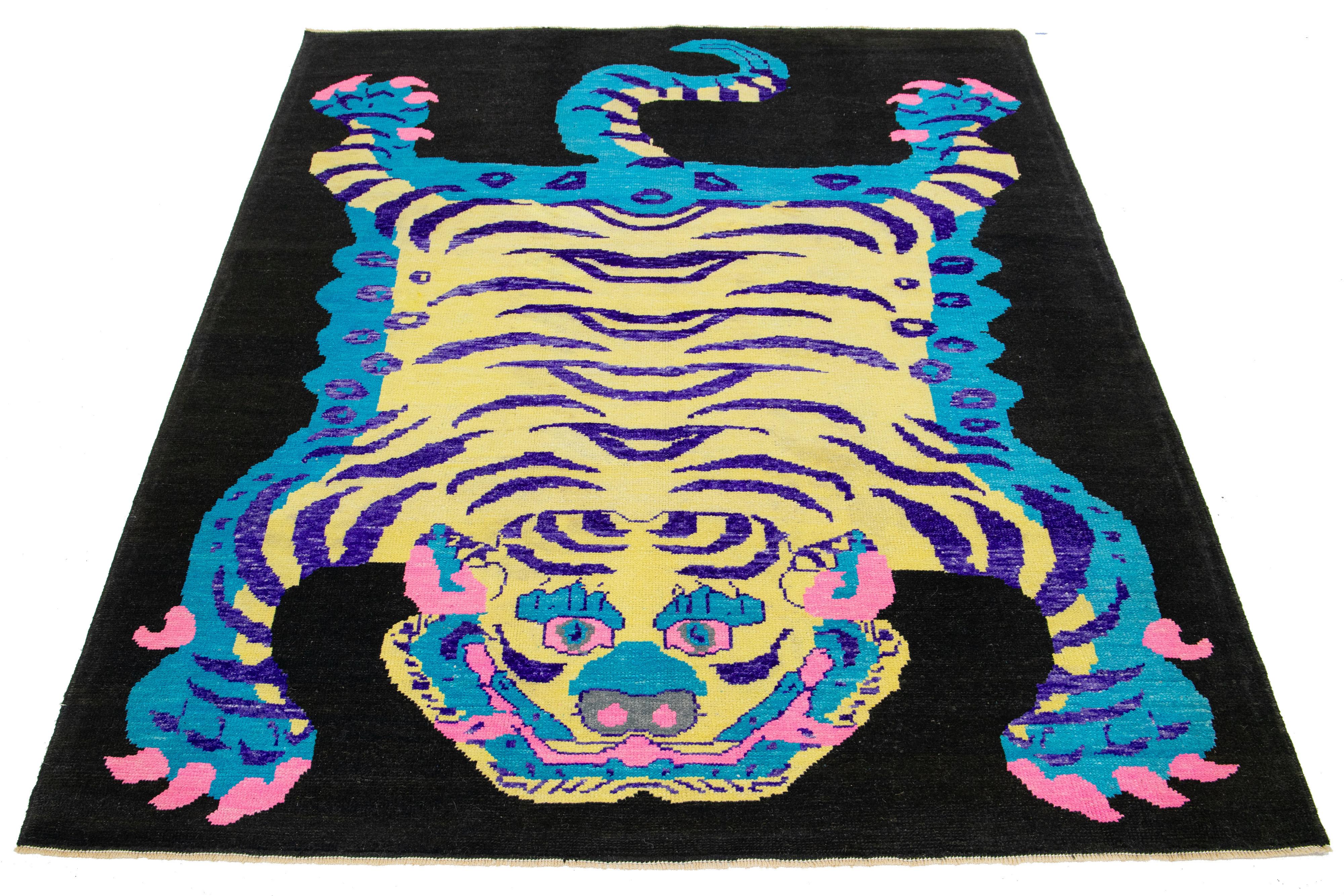 Ce magnifique tapis en laine Art déco turc fait à la main présente un champ noir. Il présente des couleurs bleues, beiges, violettes et roses dans un superbe motif tigré.

Ce tapis mesure 7' x 9'8