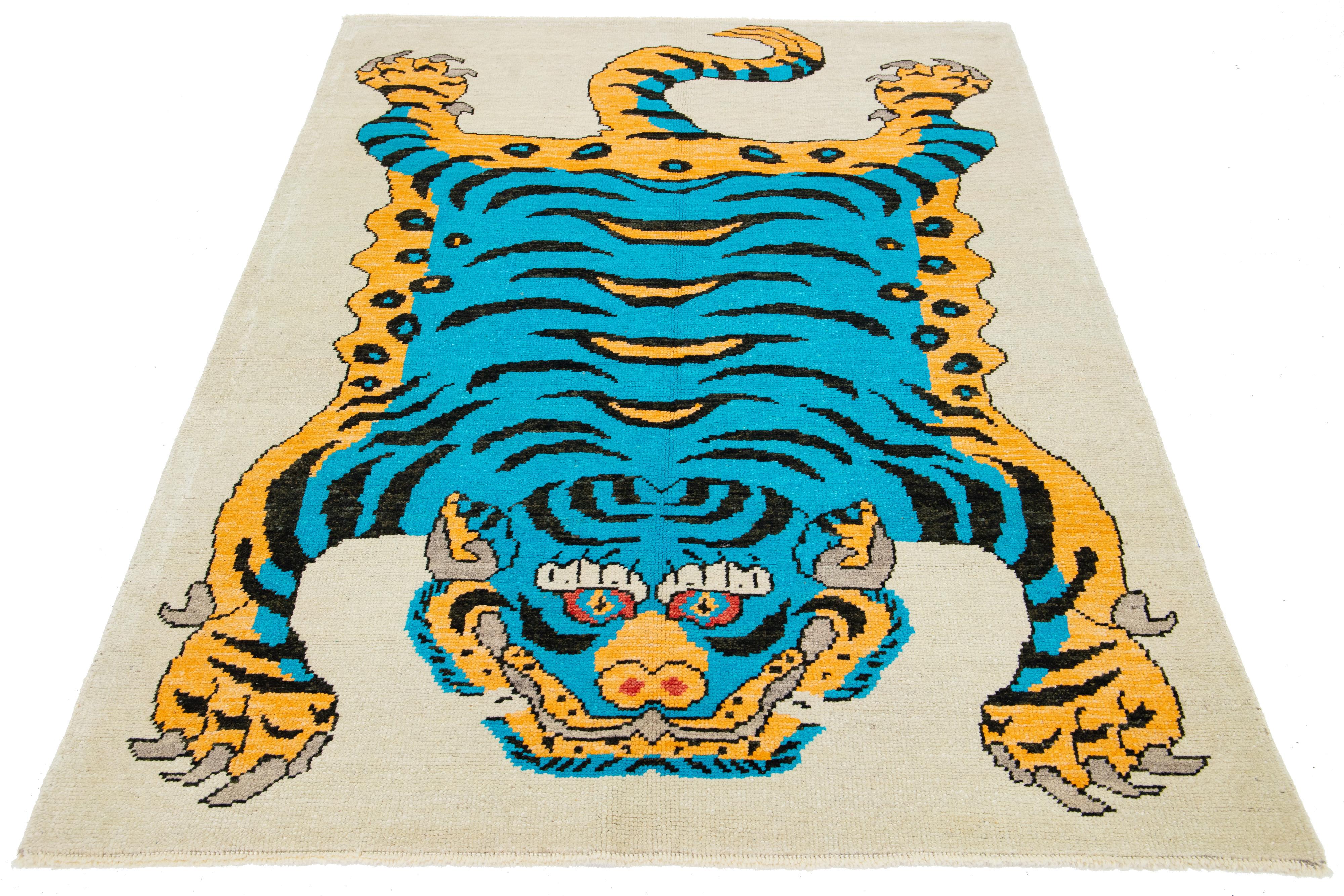 This is a beautiful handmade Turkish Art Deco wool rug with a beige field. It features blue, goldenrod, and black accent colors in a stunning tiger pictorial design.

This rug measures 5'3